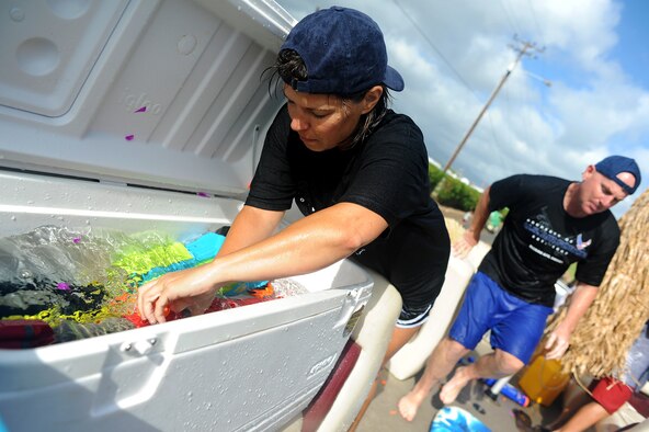 JOINT BASE PEARL HARBOR HICKAM, Hawaii -- Kelly Barrett, wife of Col. Sam Barrett, 15th Wing commander, reloads their weapons during a water fight during the annual Beach Bum Parade May 21 on Hickam. Colonel Barrett and his family took on spectators with water balloons, fire hoses, water guns, water cannons and water hoses as they rolled by in the parade. The parade began at Bishop's Point Pier and ended at Hickam Harbor with free food and entertainment at Foster Point Pavilion. Those who wanted to were able to campout at Hickam Harbor after the parade for a fun, family night, gathered around a campfire for free s'mores. Once the sun set, campers enjoyed a movie on the beach on a large outdoor movie screen. (U.S. Air Force photo/Staff Sgt. Mike Meares)
