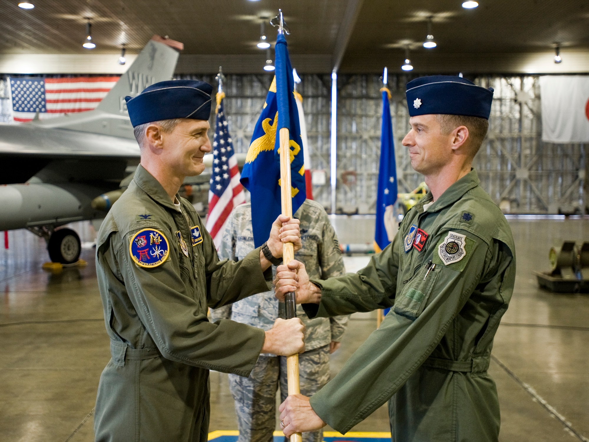 MISAWA AIR BASE, Japan -- Lt. Col. Greg Kreuder, former 14th Fighter Squadron director of operations, receives the 13th Fighter Squadron guidon from Col. John Pearse, 35th Operations Group commander during a change of command ceremony May 26 at Hangar 911. Colonel Kreuder assumed command of the 13th FS from Lt. Col. Jay Aanrud. (U.S. Air Force photo/Senior Airman Jamal D. Sutter)