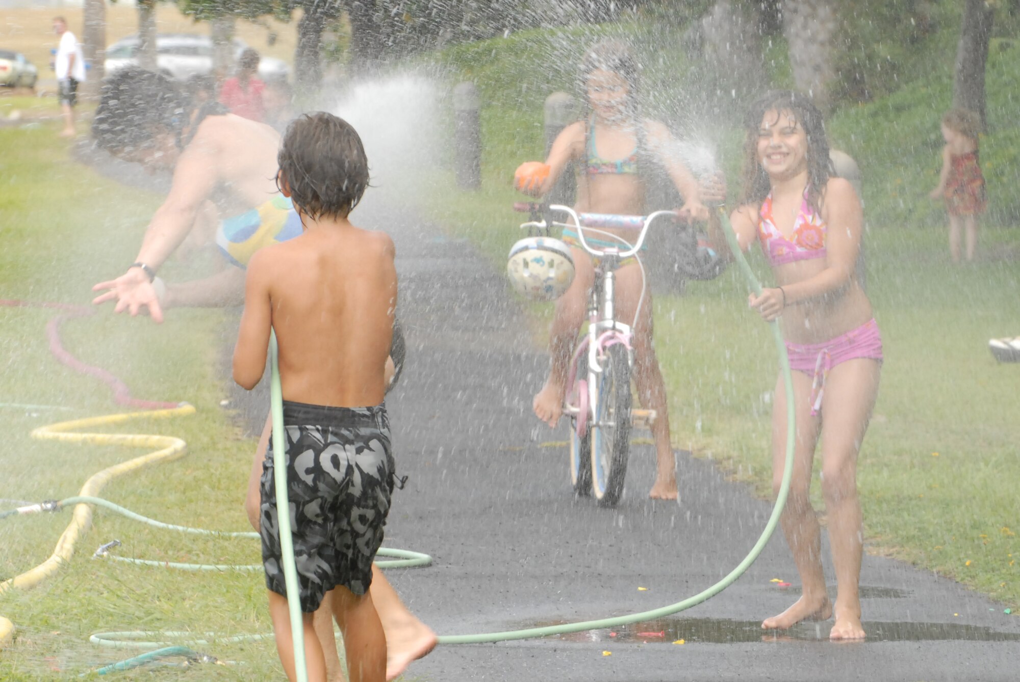 JOINT BASE PEARL HARBOR HICKAM, Hawaii -- Logan Loper water fights with spectators prior to the start of Hickam's annual Beach Bum Parade May 21. The parade began at Bishop's Point Pier and ended at Hickam Harbor with free food and entertainment at Foster Point Pavilion. Those who wanted to were able to campout at Hickam Harbor after the parade for a fun, family night, gathered around a campfire for free s'mores. Once the sun set, campers enjoyed a movie on the beach on a large outdoor movie screen. (U.S. Air Force photo/Staff Sgt. Mike Meares)