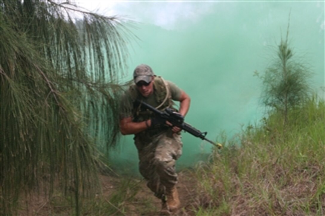 U.S. Marine Corps Lance Cpl. Mykel Thaete, of the Advanced Infantry Training Battalion, School of Infantry West, Detachment Hawaii, runs for concealment after popping an M18 green smoke hand grenade at Kahuku Training Area in Hawaii on May 19, 2010.  Thaete participated as opposition force in an attack and defend field exercise as part of School of Infantry West's Infantry Squad Leader Course.  