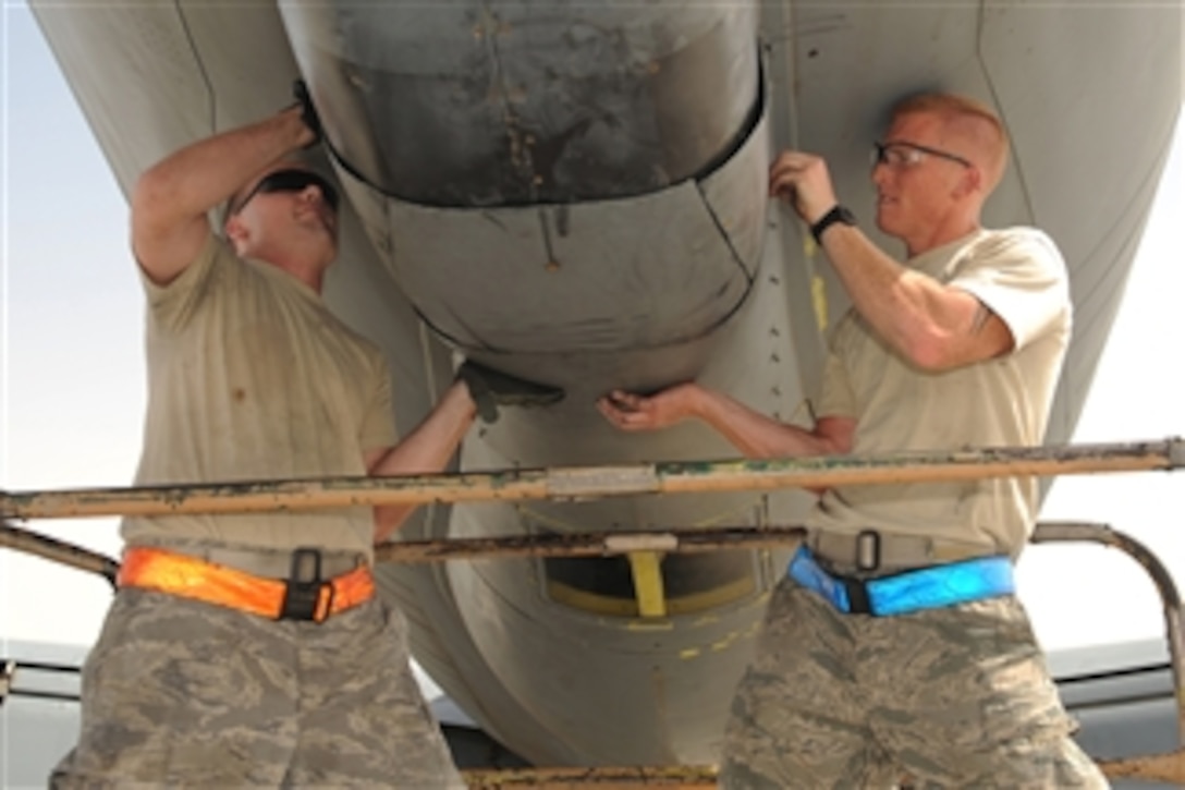 U.S. Air Force Tech. Sgt. Todd Clow and Senior Airman Christopher Hughes, hydraulics technicians with the 379th Expeditionary Aircraft Maintenance Squadron, attach a boom pod fairing panel to a KC-135 Stratotanker at a Southwest Asia location on May 13, 2010.  