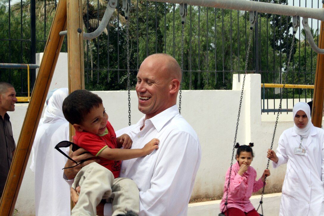 Staff Sgt. Matthew Dover, a reserve Marine from Company A, Intelligence Support Battalion, Marine Forces Reserve in San Diego, shares a laugh with a child at the Tazzanine Association orphanage here May 26.  The orphanage visit was an independent initiative on the part of U.S. service members who are here for African Lion 2010, a Marine Forces Africa-led exercise involving about a thousand U.S. Marine, Navy, Army and Air National Guard reservists.  .::r::::n::U.S. Marine Corps photo by Maj. Paul Greenberg::r::::n::