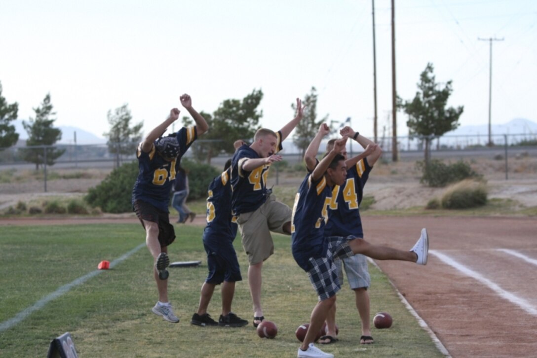 MARINE CORPS AIR GROUND COMBAT CENTER TWENTYNINE PALMS, Calif.—Navy Shark cheerleaders rouse the crowd’s excitement by going wild for their girls on the sidelines during a Marines versus Navy powder puff football game at Felix Field May 27. The Navy lost 40-12.::r::::n::