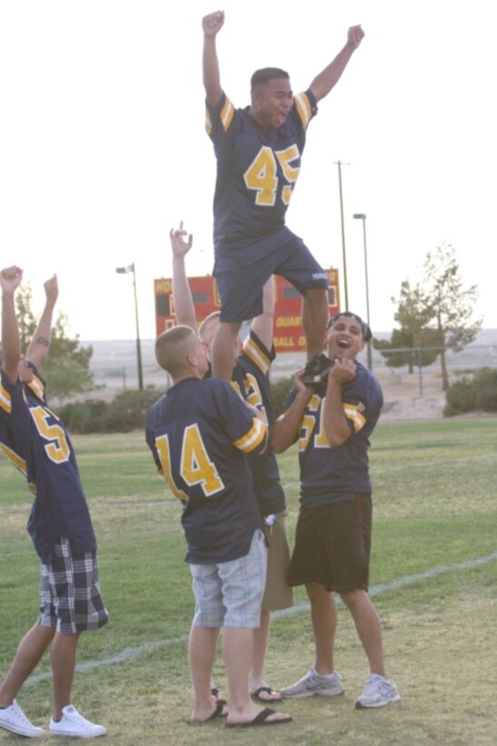 MARINE CORPS AIR GROUND COMBAT CENTER TWENTYNINE PALMS, Calif.— Navy Shark cheerleaders form a basic pyramid to rouse the crowds excitement during a Marines versus Navy powder puff football game at Felix Field May 27. The Marines won, 40-12.