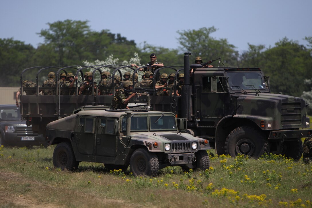 Romanian Marines arrive via tactical vehicles to conduct military operations in urbanized terrain during the final training exercise of their peacekeeping operations training, May 27. Romanian Marines and soldiers capped off two weeks of training with U.S. Marines and Sailors with a final exercise and ceremony.