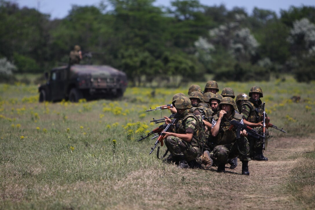 Romanian Marines move into position during the military operations on urbanized terrain portion of their final training exercise, May 27. Throughout two weeks of training with the U.S. Marines and Sailors of Black Sea Rotational Force, the Romanian troops practiced MOUT training, nonlethal weapons use, martial arts and other skills crucial to peacekeeping operations.