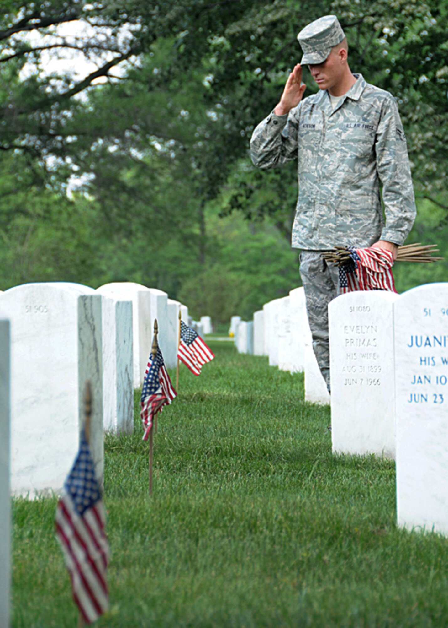 Airman 1st Class Matthew Acheson, U.S. Air Force Honor Guard ceremonial guardsman, places flags at Arlington National Cemetery headstones May 27 in honor of  America's fallen heroes. The flags-in ceremony was held in conjunction with the Memorial Day weekend.  (U.S. Air Force photo by Thomas Dennis)