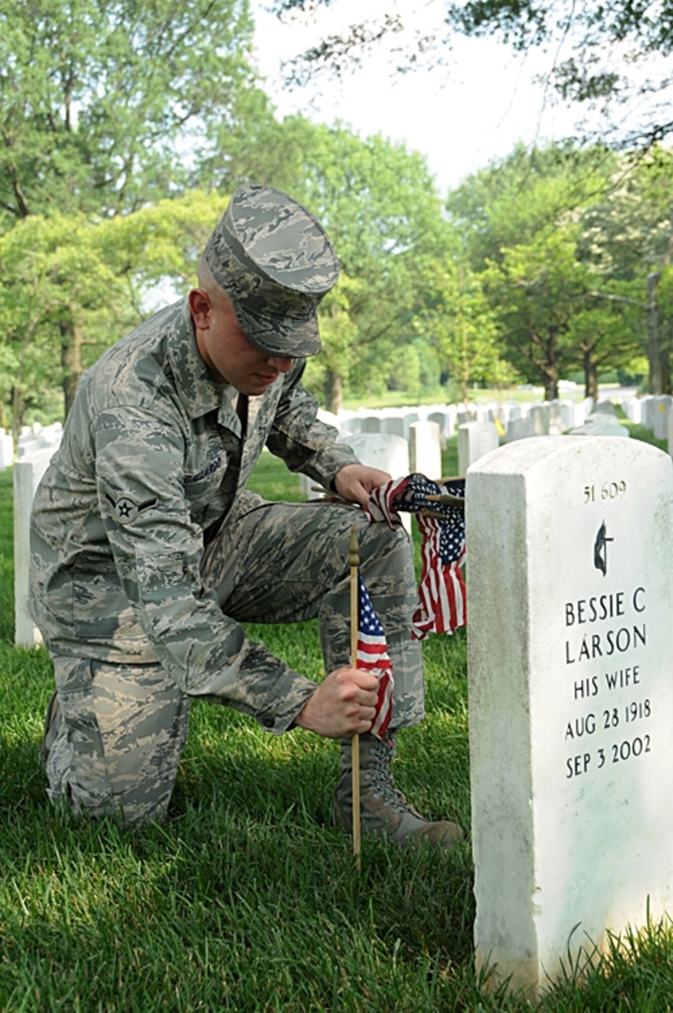 Airman Osmin Gallardo, U.S. Air Force Honor Guard ceremonial guardsman, places flags at Arlington National Cemetery headstones May 27 in honor of  America's fallen heroes. The flags-in ceremony was held in conjunction with the Memorial Day weekend.  (U.S. Air Force photo by Thomas Dennis)