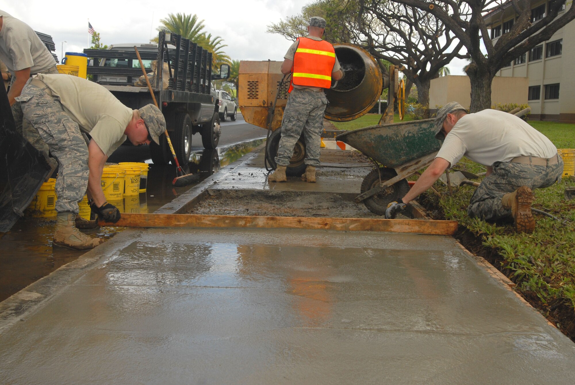 JOINT BASE PEARL HARBOR HICKAM, Hawaii – Airman 1st Class Robert Clark, 647th Civil Engineer Squadron, loads a wheel barrel with concrete to repair a sidewalk here, May 27. The sidewalk was damaged from a tree who’s roots grew out from underneath and created a safety hazard. (U.S. Air Force photo/Senior Airman Gustavo Gonzalez)