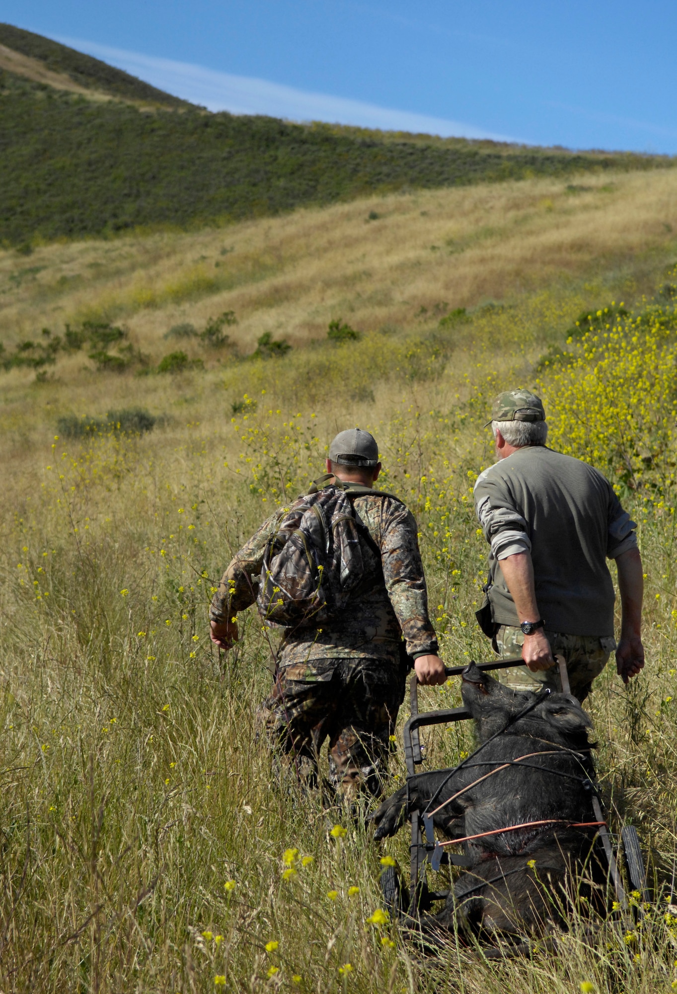 VANDENBERG AIR FORCE BASE, Calif. -- Dragging their prized boar, Steve Reisbeck, a local hunter, and Army Sgt. Kisha Makerney, of the 45th Infantry Brigade, 777th Aviation Company, take their pig to be cleaned during a Wounded Warriors Pig Hunt here Thursday, May 27, 2010. The Wounded Warriors Project provides programs and events to service members who have been injured in combat to boost morale. (U.S. Air Force photo/Senior Airman Andrew Lee) 
