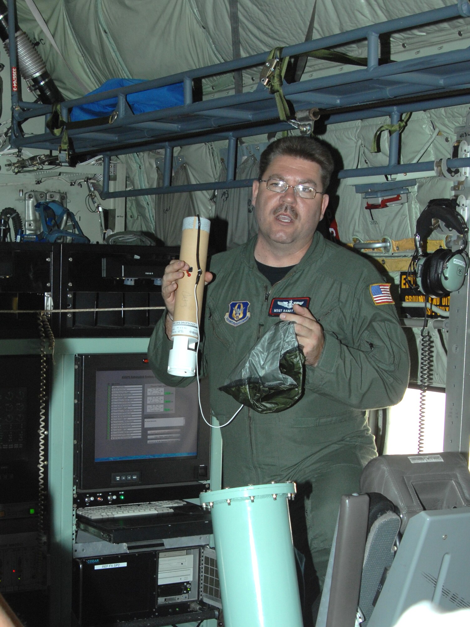 Master Sgt. Randy Bynon, a member of the 53rd Weather Reconnaissance
Squadron's Hurricane Hunters aircrew, demonstrates the process of releasing
a dropsonde weather reconnaissance device through a tube in the WC-130J
aircraft. The Hurricane Hunters crew visited D-M May 21 to meet and interact
with members of the 612th Support Squadron, who provide flight weather
support for 53rd WRS missions. (U.S. Air Force photo/Staff Sgt. Jake
Richmond)
