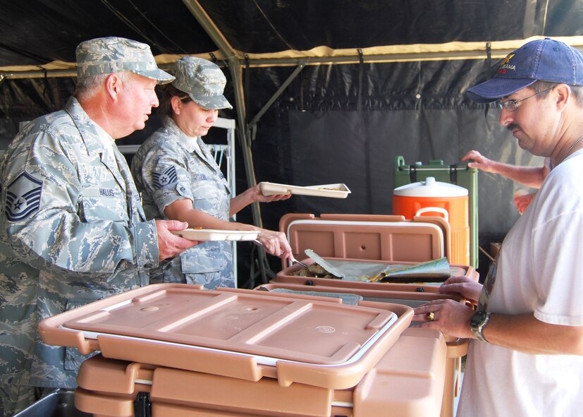 Working from their single-pallet expeditionary kitchen, Air Force reservists Master Sgt. Scott Halus, left, and Tech. Sgt. Sonya Lees, 919th Services Flight, serve a hot meal to an attendee at the Military Appreciation Recognition Celebration May 15 at Old Spanish Trail Park in Crestview.  Several units from Duke Field's 919th Special Operations Wing brought out various displays of military equipment for the public to see.  The MARC is a non-profit organization seeking to honor past and present military members of all branches during the Armed Forces Day weekend. (U.S. Air Force photo/Tech. Sgt. Cheryl Foster)