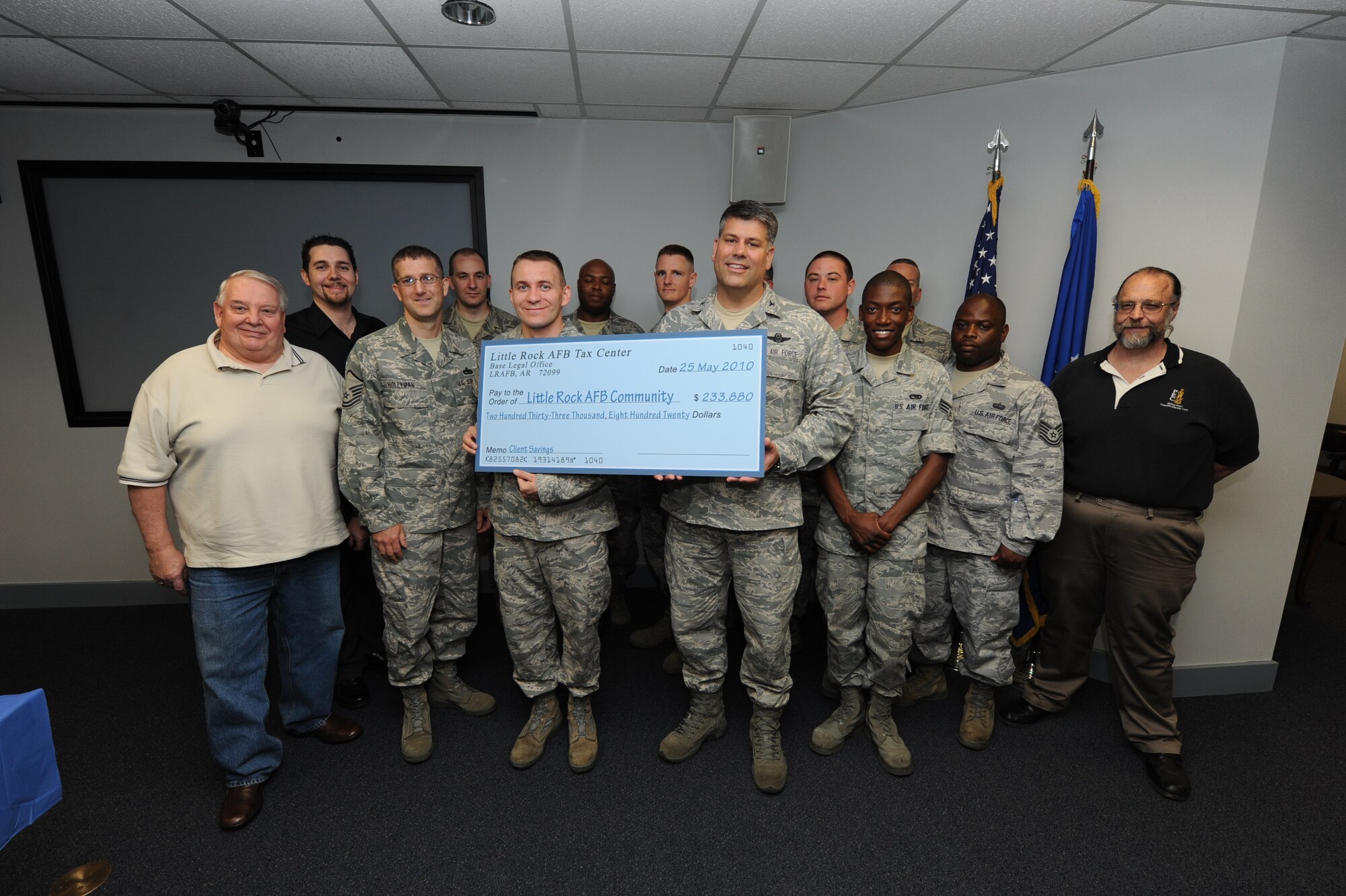 Col. Greg Otey, 19th Airlift Wing commander, presents a check May 25 to members of the 2009 Volunteer Income Tax Center to signify the estimated amount saved in preparation fees. Twenty-three volunteers from around base completed 1,405 tax returns, saving military members and their families an estimated $233,880 during the 2009 income tax preparation season. (U.S. Air Force photo by Senior Airman Ethan Morgan)