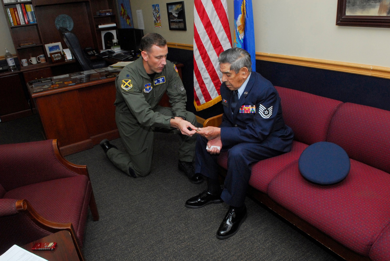 Lt. Col. Matthew Whiat, 323rd Training Squadron commander, presents retired Tech. Sgt. Joseph Alexander with a commander's coin. (U.S. Air Force photo/Alan Boedeker)
