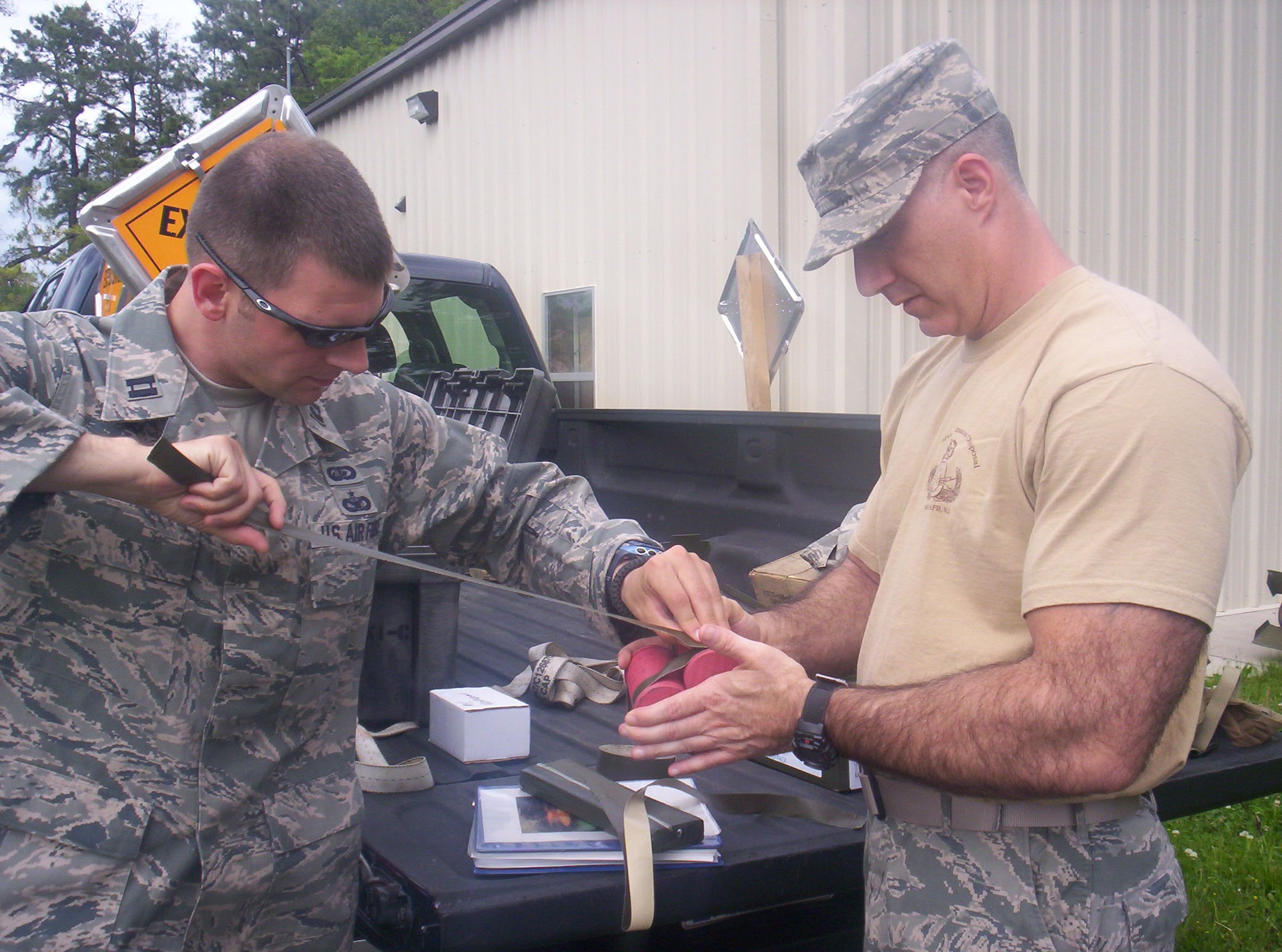 Capt. Christopher Mazzei and Senior Master Sgt. Frank Bruno, 514th Explosive Ordnance Disposal flight, bundle thermite grenades duing a monthly demolition activity here May 21. (Courtesy photo/Dan Cosgrove