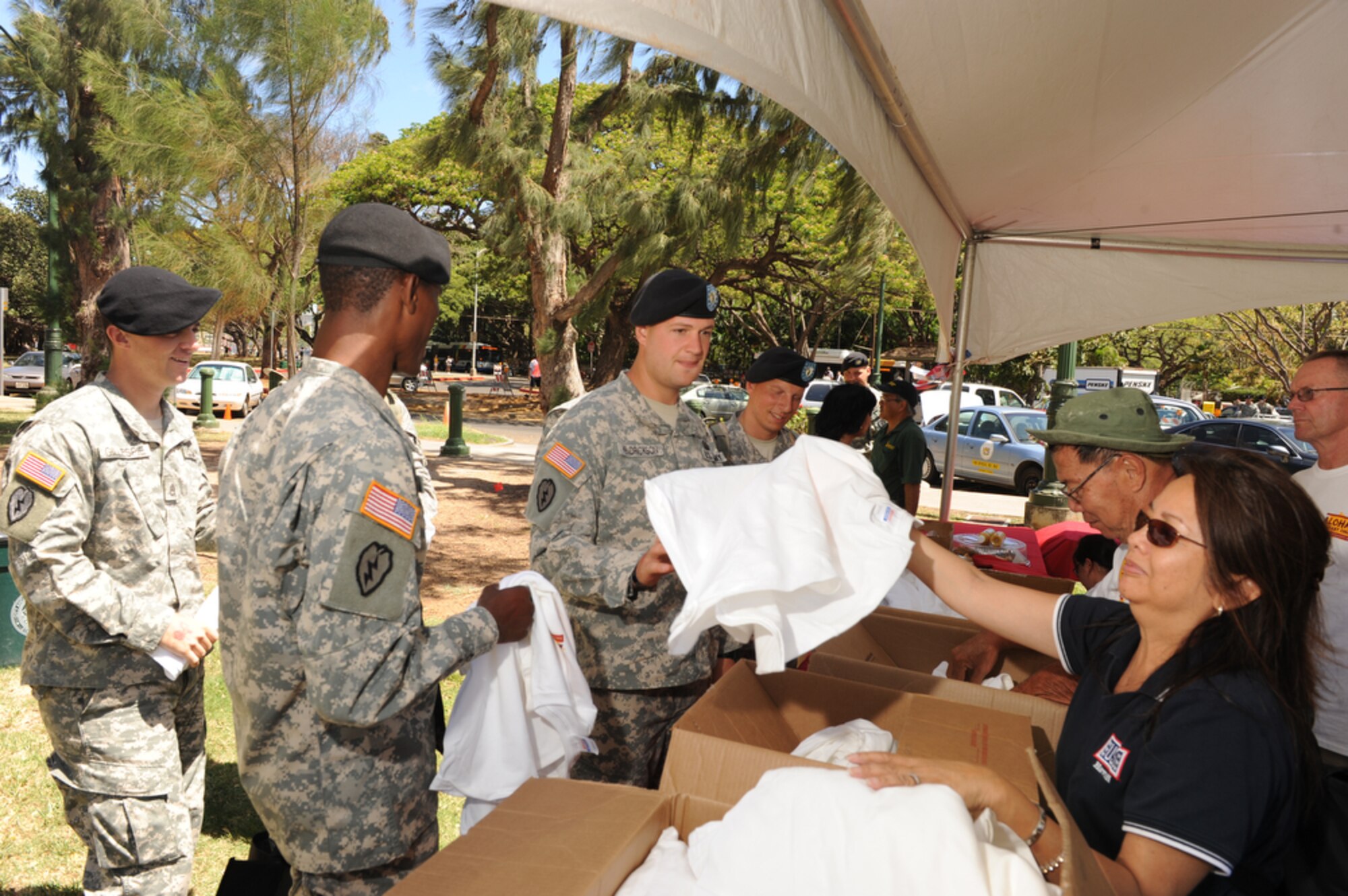 HONOLULU - United Services Organizations volunteers hand out Military Appreciation T-Shirts during Military Appreciation Day activities at Kapiolani Park in Honolulu, Hawaii on May 22. Active duty, guard and reserve military members participated in a Welcome Home Parade, which was followed up with entertainment at the Waikiki Shell with performances by four local Hawaii bands and a military joint jazz ensemble. The event was organized by the USO, the Chamber of Commerce Military Affairs Council and BAE Systems. (U.S.  Air Force photo/Tech Sgt. Cohen A. Young)