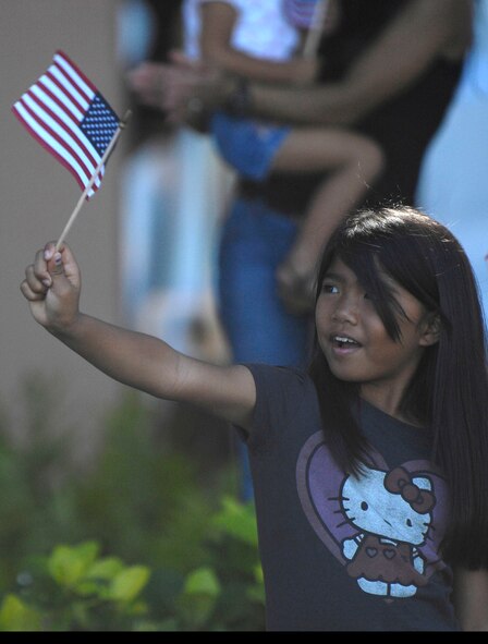 HONOLULU - A little girl waves her American flag as active duty, guard and reserve personnel from the Army, Navy, Air Force, Marines and Coast Guard walk by in formation as part of a Welcome Home Parade, which was one of many Military Appreciation Day events held in Honolulu on May 22. The parade was followed up with entertainment at the Waikiki Shell with performances by four local Hawaii bands and a military joint jazz ensemble. The event was organized by the USO, the Chamber of Commerce Military Affairs Council and BAE Systems. (U.S.  Air Force photo/Tech Sgt. Cohen A. Young)