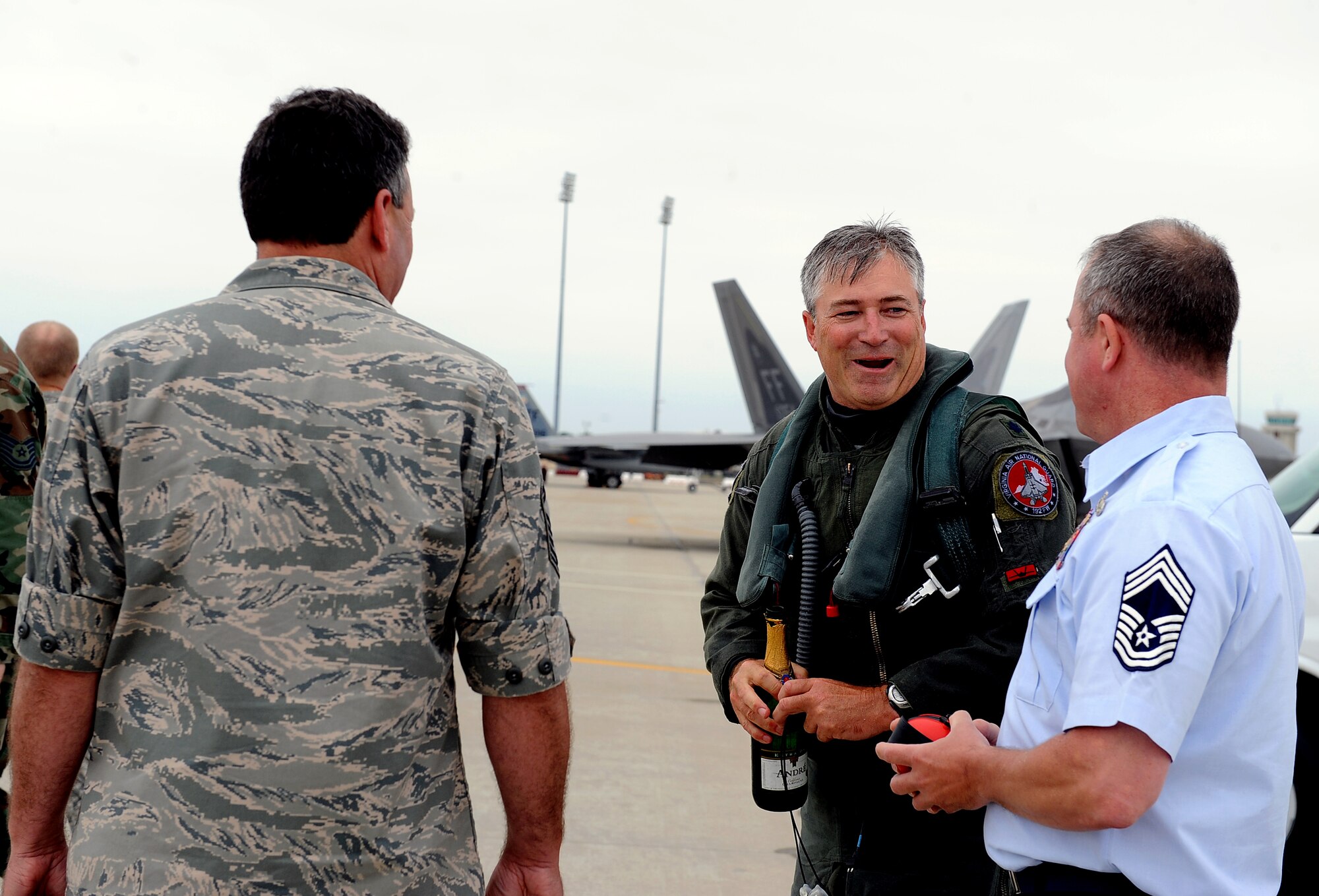 LANGLEY AIR FORCE BASE, Va. -- Senior Master Sgt. David Beahr, 192d Fighter Wing noncommissioned officer in charge, and Chief Master Sgt. Michael Bouley, 192 FW maintenance group chief, speak to Lt. Col. Robert Sandford, 192 FW chief of standardization and evaluation, after surpassing 4,000 flight hours May 17. The veteran pilot said he plans to stay with the 192 FW “as long as possible,” recently volunteering for a deployment to Guam with the 27th Fighter Squadron. (U.S. Air Force photo/Airman 1st Class Gul Crockett)