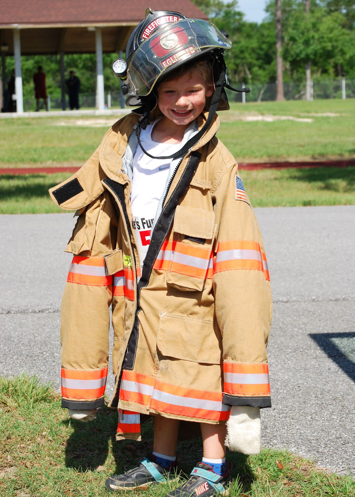 Daniel Dunn tries on a Duke Field firefighter’s fire suit and helmet following the annual Duke Field Kids’ Fun Run and Adult 5K May 15.   The firefighters, on hand to provide standby emergency medical support for the runners, also took time show them their fire truck and its firefighting equipment .  The event coincided with the Air Force-wide America’s Armed Forces Kids’ Run.    First-place finishers by respective age category included:  Nicholas Ruiz, 5-6 half mile; Faith Alexander, 7-8 half mile; Austin Bonebrake, 9-13 one mile; and Eric Bonebrake, adult 5K.  (U.S. Air Force photo/Tech. Sgt.  Cheryl Foster)