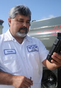 Eddie Cortez, a 902nd Logistics Readiness Squadron Fuels Management contractor, uses a Fuels Dispensing Personal Digital Assistant to read the amount of fuel being dispensed.  (U.S. Air force Photo By Don Lindsey)