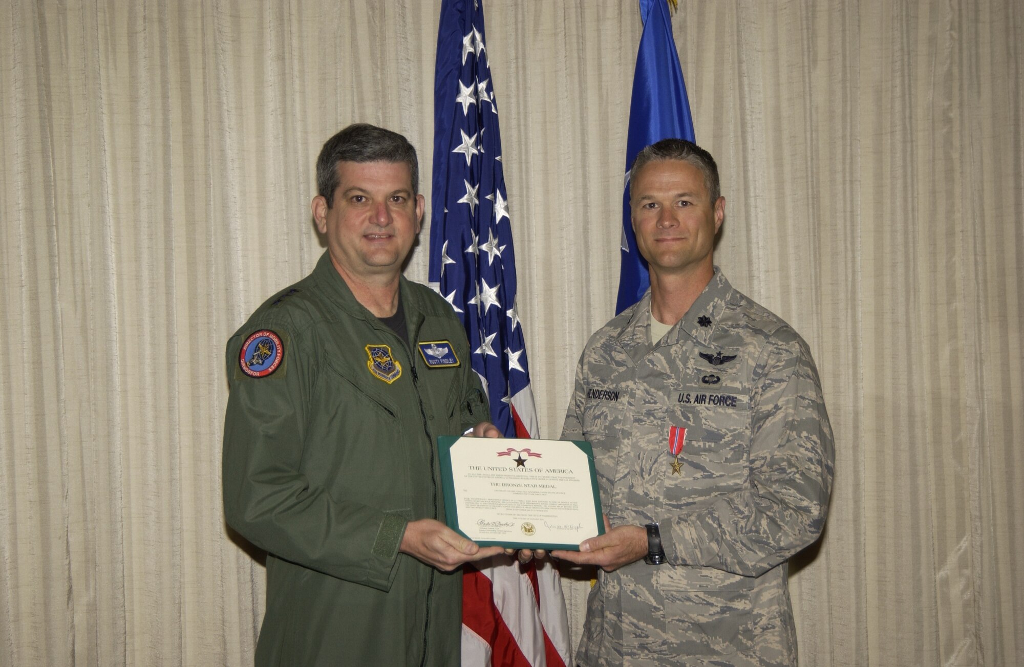 Lt. Col. Charles Henderson, Air Mobility Command Test and Evaluation
Squadron commander, accepts a Bronze Star from Lt. Gen. Rusty Findley, Air
Mobility Command vice commander, for his deployment in Baghdad, Iraq from
Sept. 20, 2009 to Mar. 31, 2010.  