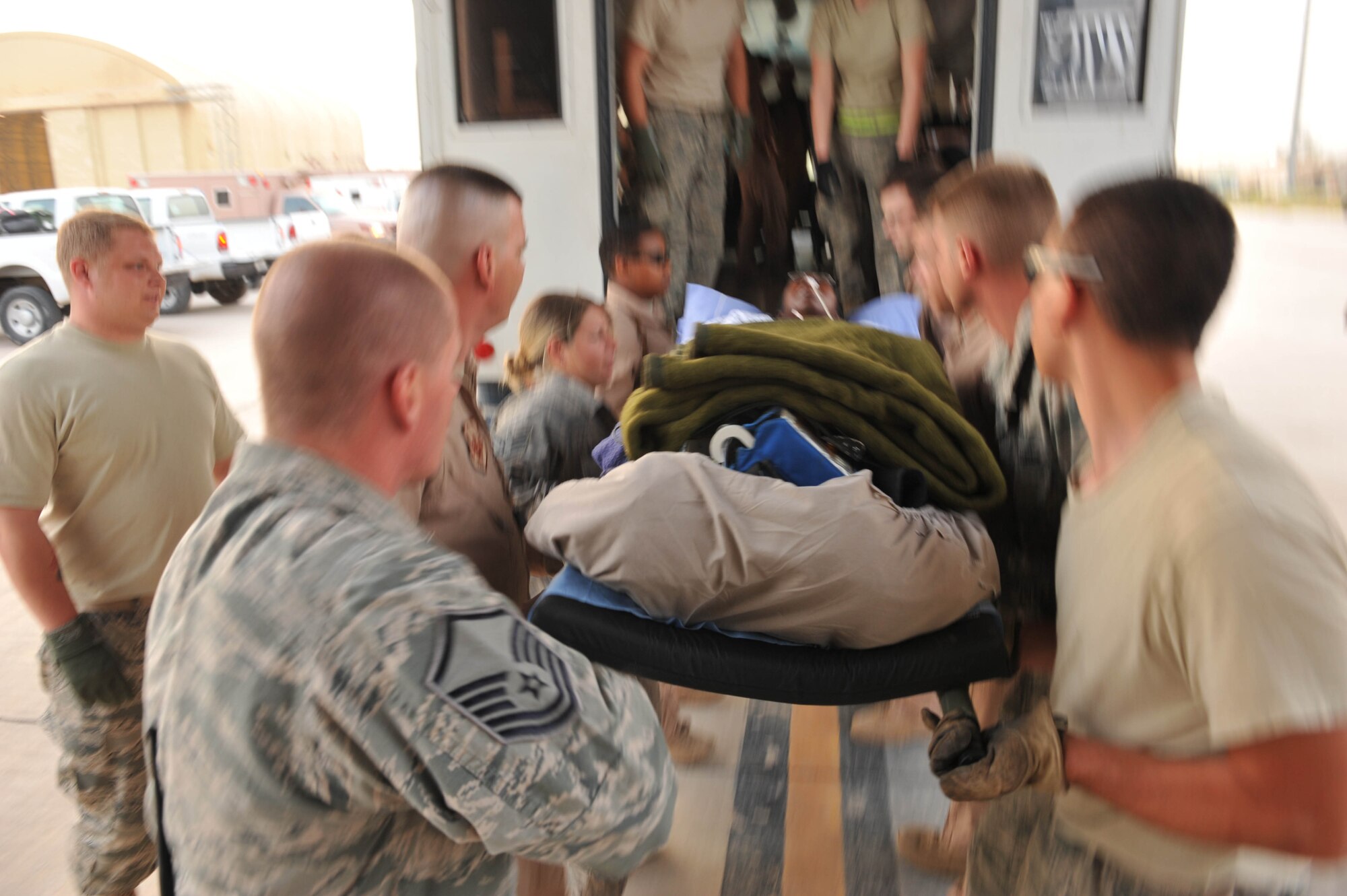 U.S. Air Force medical personel  from the 332nd Expeditionary Aeromedical Evacuation Flight prepare to load a patient into a bus afteran aeromedical evacuation flight from a base in Southwest Asia to Joint Base Balad, Iraq, May 13, 2010.  (U.S. Air Force photo/Staff Sgt. Quinton Russ/released)