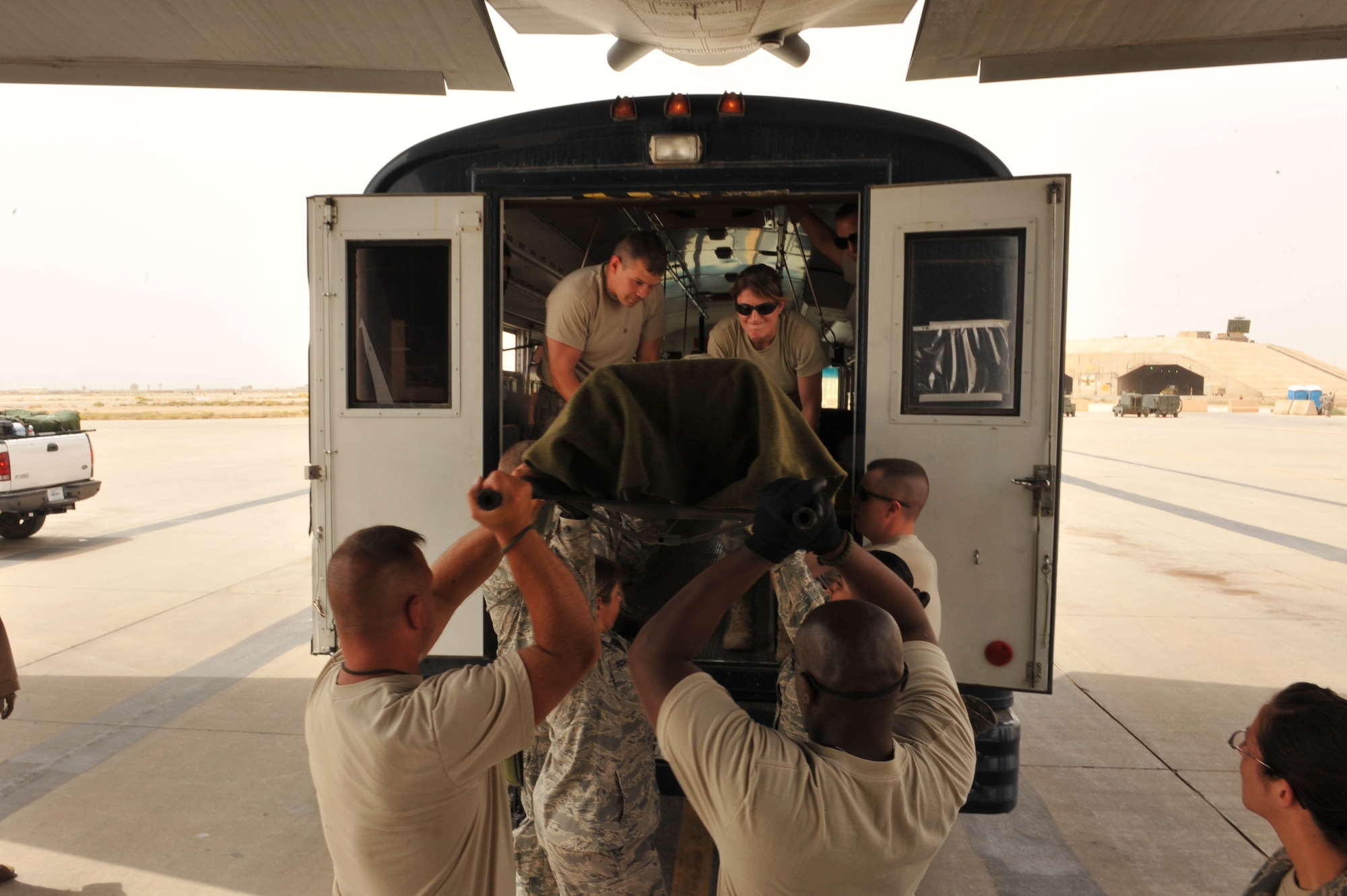 U.S. Air Force medical personel from the 332nd Expeditionary Aeromedical Evacuation Flight prepare to load a patient into a bus after an aeromedical evacuation flight from a base in Southwest Asia to Joint Base Balad, Iraq, May 13, 2010.  (U.S. Air Force photo/Staff Sgt. Quinton Russ/released)