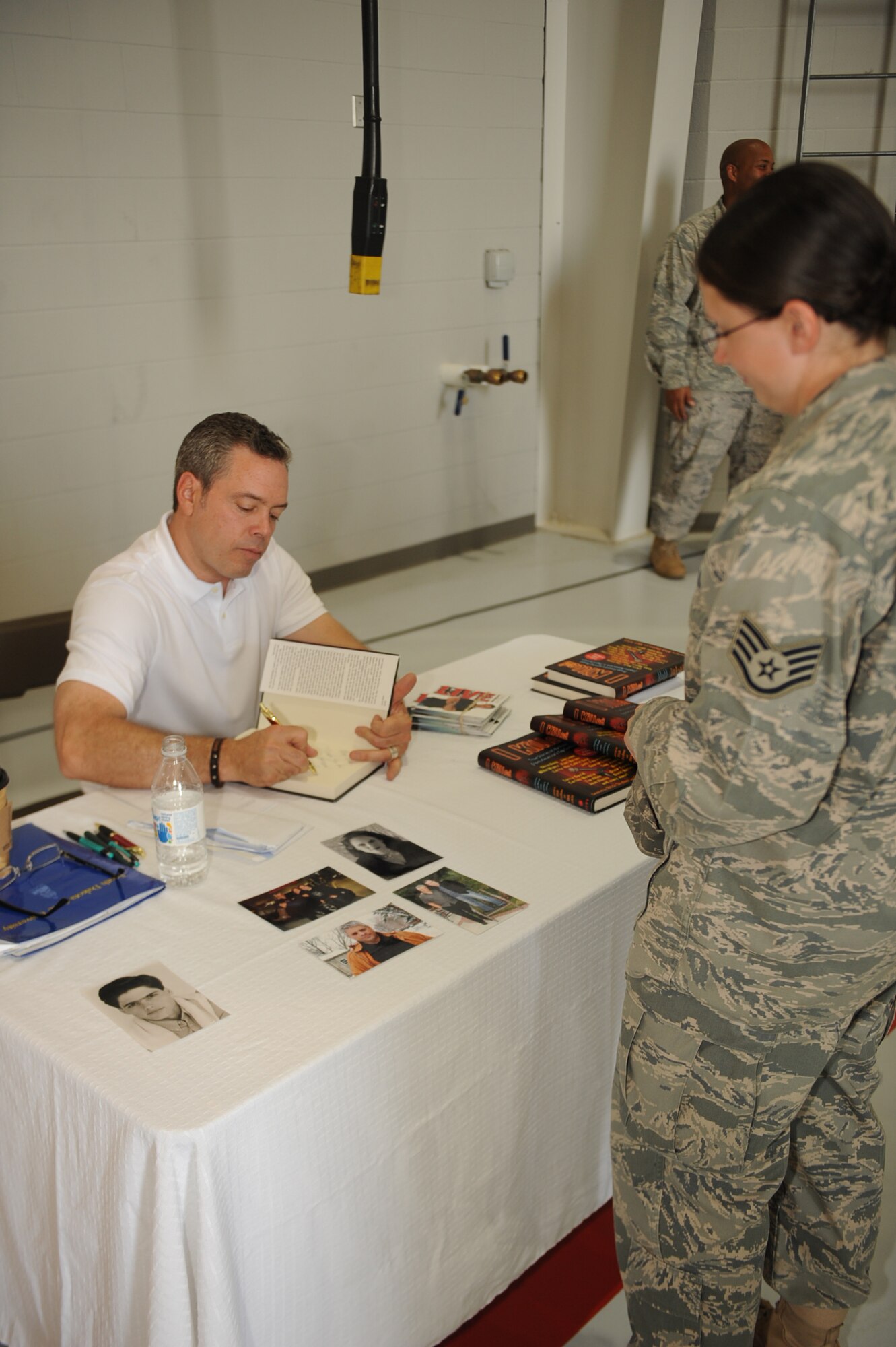 SEYMOUR JOHNSON AIR FORCE BASE, N.C. -- Comedian Bernie McGrenahan signs a book for StaffSgt. Mary Stake after a "happy hour" comedy show and safety talk, May 21, 2010. "Happy Hour" was held to raise awareness and encourage the base population to practice safe behaviors. Sergeant Stake, 4th Aeromedical Dental Squadron medical technician, hails from Willow Hill, Penn. (U.S. Air Force photo/ Senior Airman Ciara Wymbs)