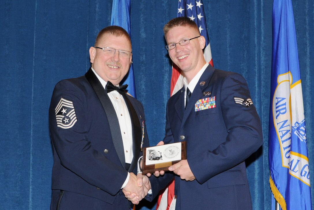 McGHEE TYSON AIR NATIONAL GUARD BASE, Tenn. -- Senior Airman Jay M. Jakeway, 148th Fighter Wing, Minnesota Air National Guard, right, receives the distinguished graduate award for Airman Leadership School Class 10-3 at The I.G. Brown Air National Guard Training and Education Center here from Chief Master Sgt. Michael R. Francis, Command Chief Master Sergeant, New Jersey Air National Guard, May 20, 2010.  The distinguished graduate award is presented to students in the top ten percent of the class.  It is based on objective and performance evaluations, demonstrated leadership, and performance as a team player.   (U.S. Air Force photo by Master Sgt. Kurt Skoglund/Released)