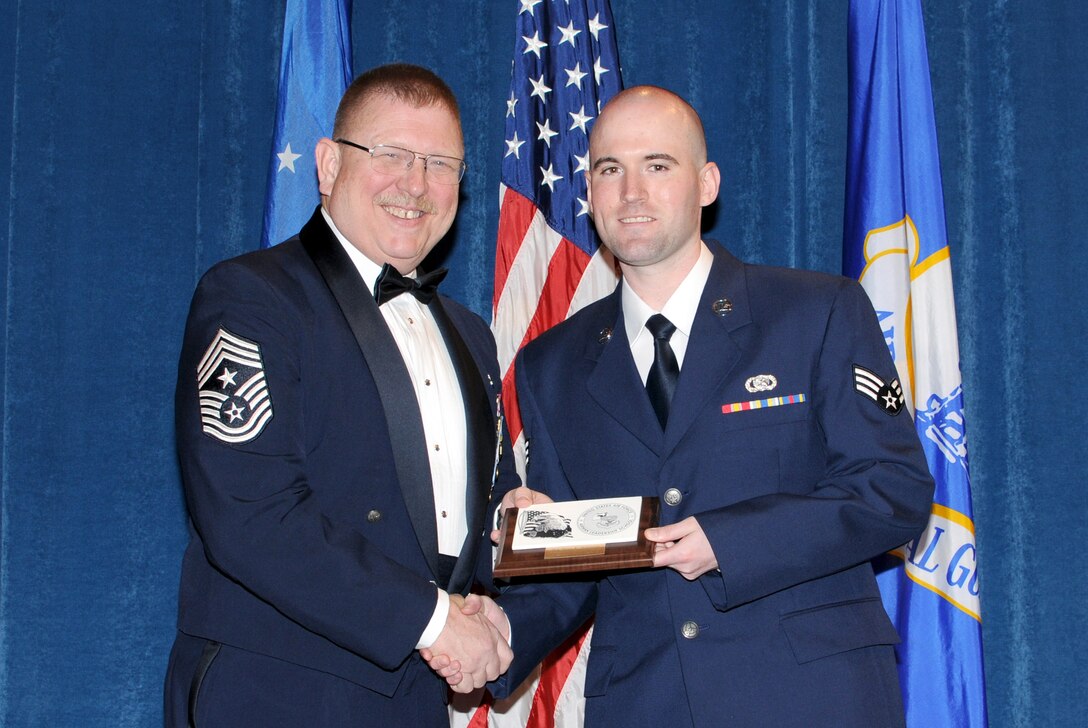 McGHEE TYSON AIR NATIONAL GUARD BASE, Tenn. -- Senior Airman Brian R. McQuillen, 271st Combat Communications Squadron, Pennsylvania Air National Guard, right, receives the distinguished graduate award for Airman Leadership School Class 10-3 at The I.G. Brown Air National Guard Training and Education Center here from Chief Master Sgt. Michael R. Francis, Command Chief Master Sergeant, New Jersey Air National Guard, May 20, 2010. The distinguished graduate award is presented to students in the top ten percent of the class.  It is based on objective and performance evaluations, demonstrated leadership, and performance as a team player. (U.S. Air Force photo by Master Sgt. Kurt Skoglund/Released)