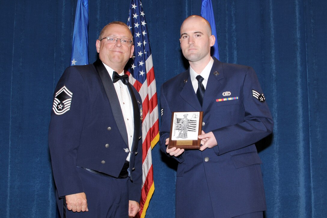 McGHEE TYSON AIR NATIONAL GUARD BASE, Tenn. -- Senior Airman Brian R. McQuillen, 271st Combat Communications Squadron, Pennsylvania Air National Guard, right, receives the academic achievement award for Airman Leadership School Class 10-3 at The I.G. Brown Air National Guard Training and Education Center here from Senior Master Sgt. Terrence Krips, EPME Director of Resources; May 20, 2010.  The academic achievement award denotes excellence as a scholar.  It is based upon all summative objective tests and individual performance evaluations and is given to the student with the highest overall academic standing. (U.S. Air Force photo by Master Sgt. Kurt Skoglund/Released)