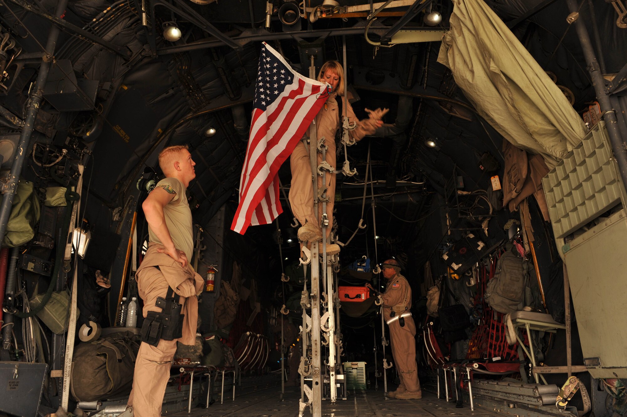 U.S. Air Force aeromedical evacuation mission crew director and flight nurse, Maj. Lisa Giugliano, hangs a flag on a C-130 Hercules before an aeromedical evacuation mission at Joint Base Balad, Iraq, May 13, 2010.  Maj. Giugliano is deployed to the 332nd Expeditionary Aeromedical Evacuation Flight, Joint Base Balad, Iraq.  (U.S. Air Force photo/Staff Sgt. Quinton Russ/released)