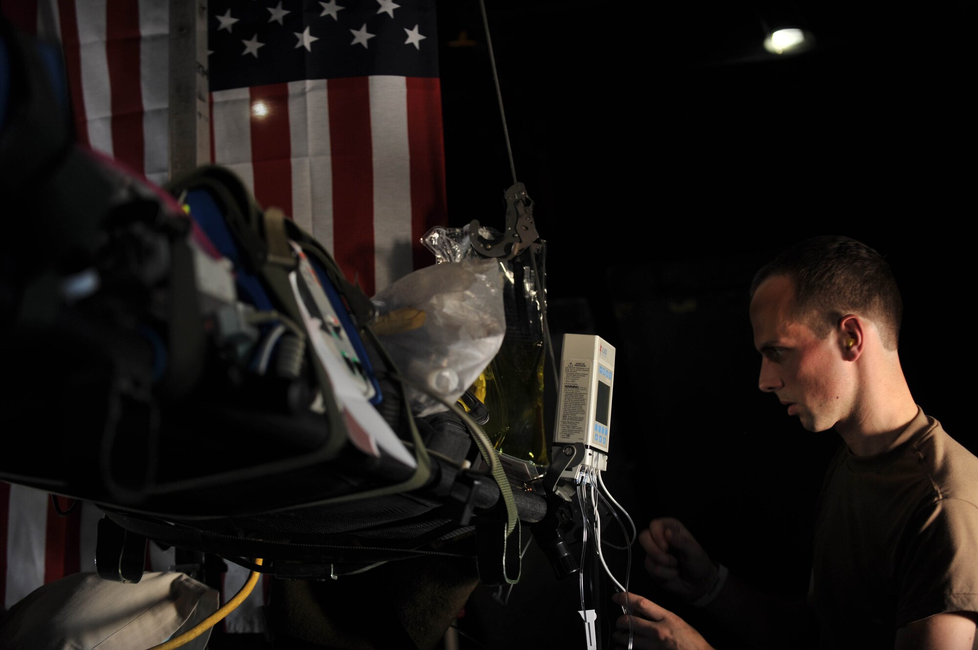 U.S. Navy nurse, Lt. J. G. Joshua Wymer, checks an IV pump during an aeromedical evacuation flight from Kuwait to Iraq, May 13, 2010.  Lieutenant Wymer is deployed to the Emergency Management Facility, Kuwait.  (U.S. Air Force photo/Staff Sgt. Quinton Russ/released)