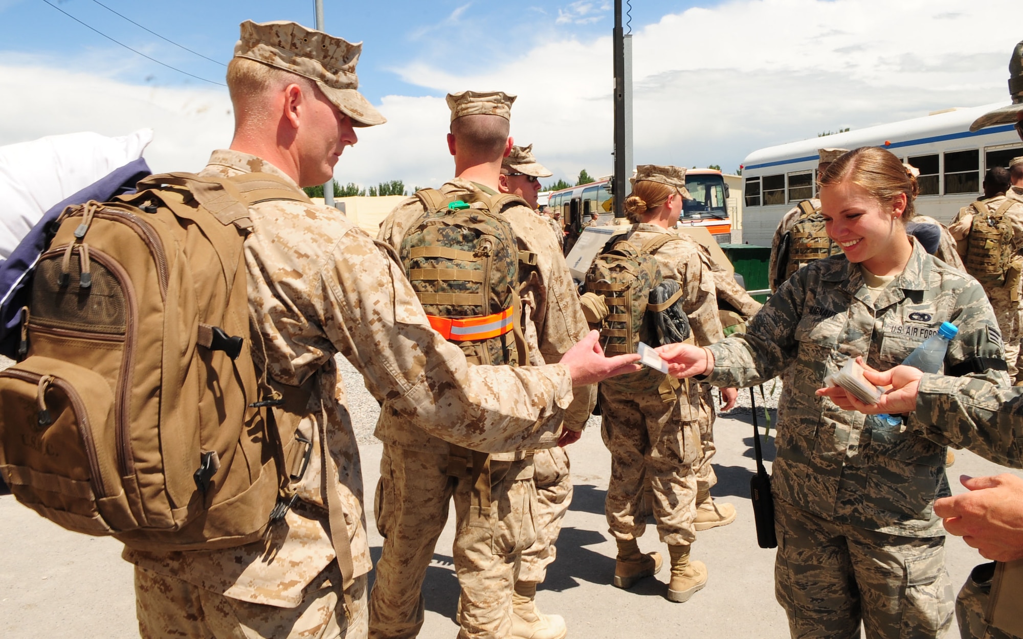 Senior Airman Jessica Blignaut, a 376th Expeditionary Logistics Readiness Squadron air terminal operations dispatcher, takes boarding passes from Marines headed home from Afghanistan to Cherry Point, N.C., via the Transit Center at Manas, Kyrgyzstan. Her team of passenger service agents processed a record-breaking 4,200 members May 16, 2010, and is likely to break a monthly record by processing more than 52,000 by the end of the month. (U.S. Air Force photo/Senior Airman Nichelle Anderson / released)