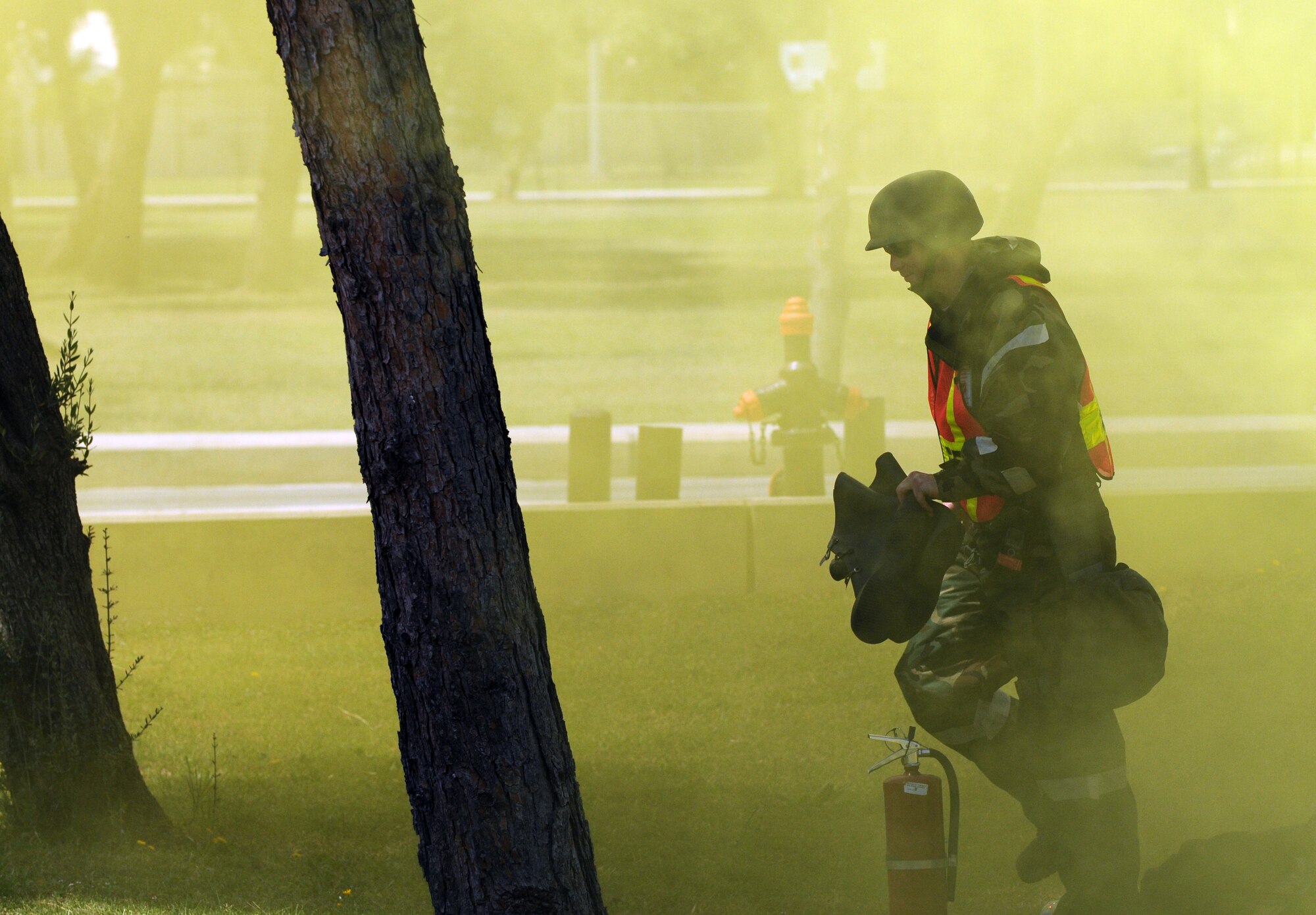 Capt. Kevin Manis, 39th Air Base Wing Exercise Evaluation Team member, prepares to don the rest of his chemical warfare suit after dropping a simulated chemical agent during an anti-terrorism exercise Tuesday, May 25, 2010 at Incirlik Air Base’s Freedom Park.  The exercise tested the base’s terrorism-response ability.  The base was put into 24-hour operations for the duration of the exercise and accomplished a number of simulated artillery and chemical attacks.  (U.S. Air Force photo/Staff Sgt. Raymond Hoy)