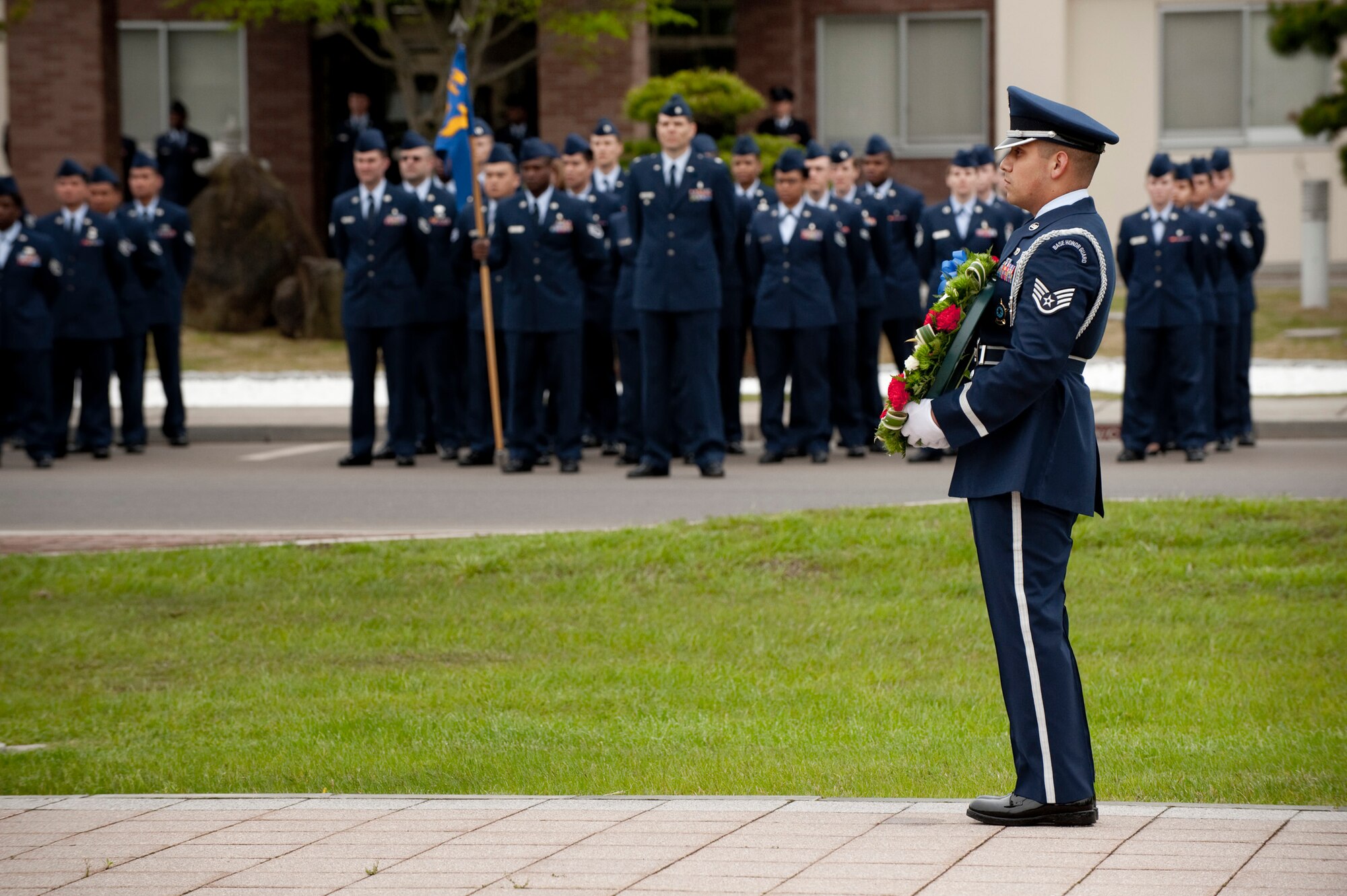 MISAWA AIR BASE, Japan -- Staff Sgt. Felipe Viesca of the Misawa Air Base honor guard stands silently holding a wreath that would be placed between the flag poles at Reisner Circle in memory of fallen service members during a Memorial Day retreat ceremony May 27. Active duty and retired military members from across the base stood in formation at Reisner Circle to pay respect. (U.S. Air Force photo/Staff Sgt. Samuel Morse)
