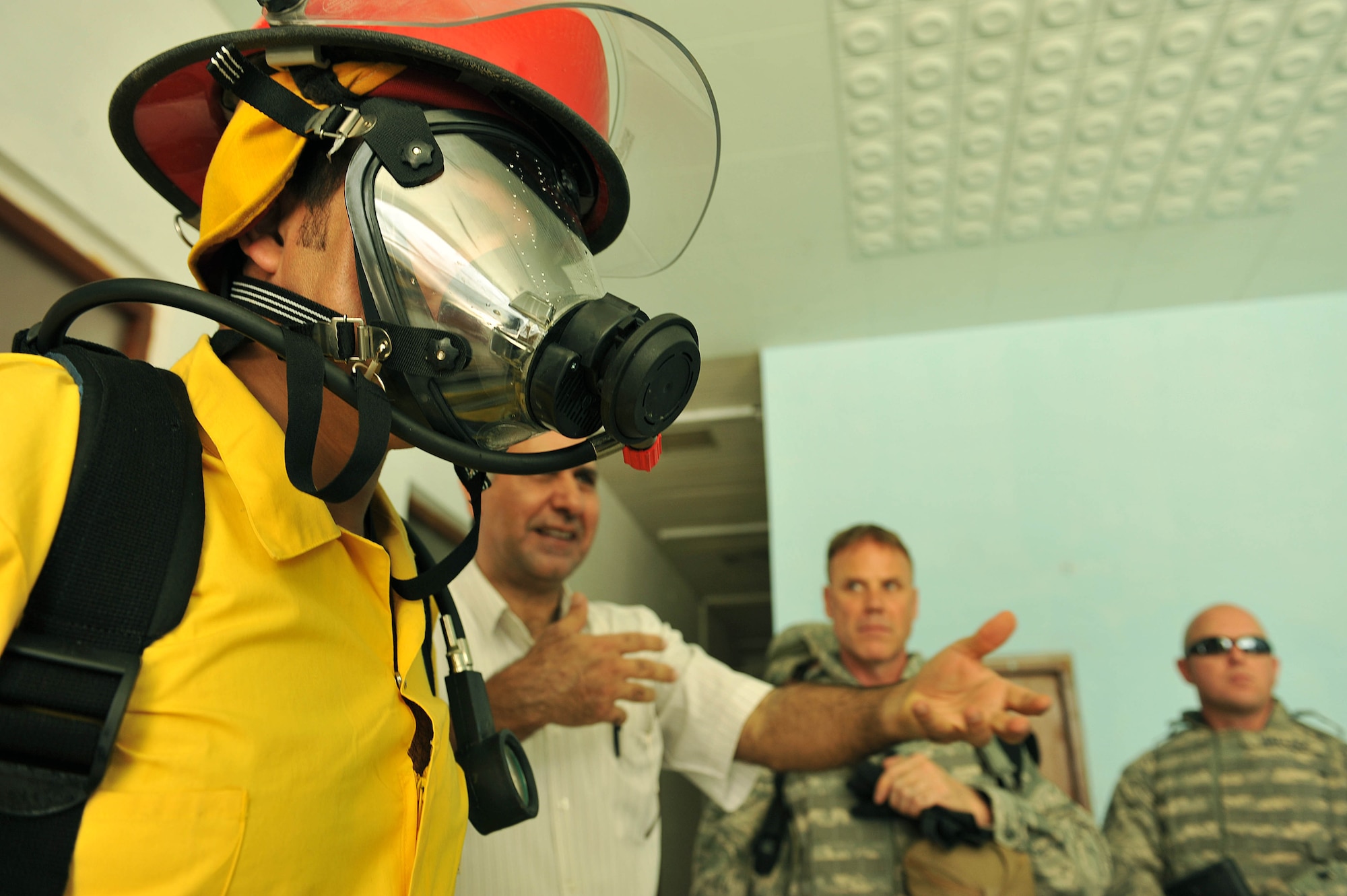 An Iraqi fireman tries on fire-protection equipment at Bakir Village, Iraq, May 7, 2010.    (U.S. Air Force photo/Staff Sgt. Quinton Russ/released)	