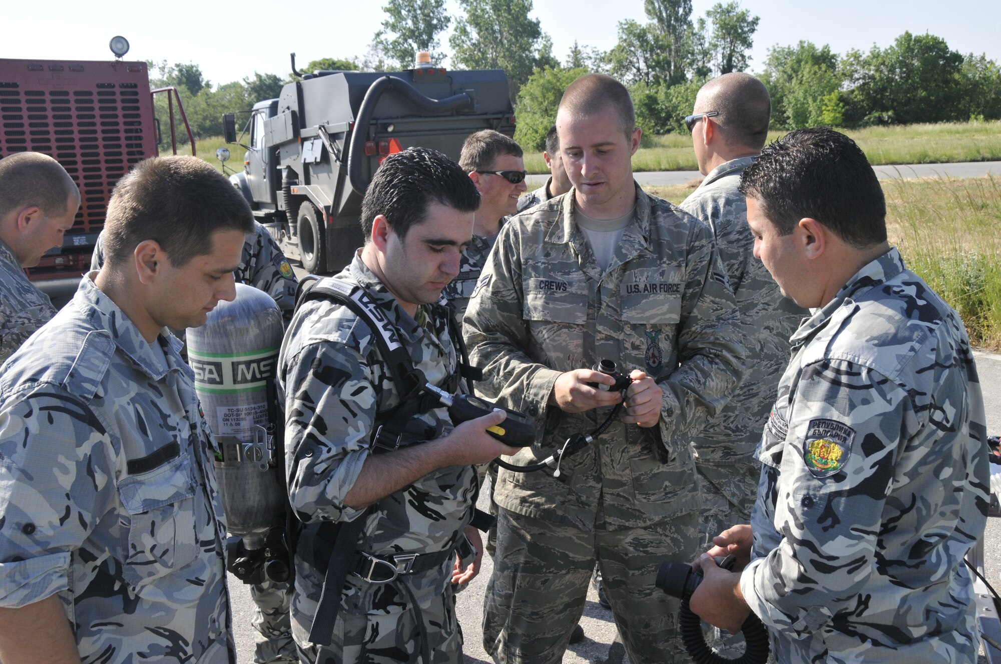 GRAF IGNATIEVO AIR FORCE BASE, Bulgaria - Airman 1st Class Phillip Crews (second from right), 48th Civil Engineer Squadron firefighter, explains the breathing apparatus used by American Airmen to Bulgarian air force firefighters. Airman Crews is in Bulgaria as part of joint-exercise Sentry Gold, an exercised designed to continue Bulgaria's integration into NATO and build partnerships between the two air forces. (Photo by Tech. Sgt. Chris Stagner)