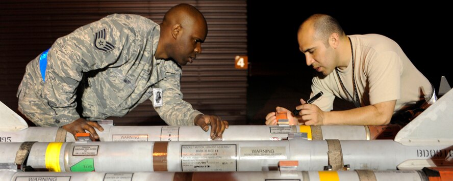 Staff Sgt. Brian Harp, left, and Tech. Sgt. Johnny Rodriquez check GBU12 munitions for technical accuracy in the in-check area of the bomb dump during the Combat Ammunitions Production Exercise at Osan Air Base, Republic of Korea, May 25. Sergeant Harp is a munitions maintainer from the 35th Munitions Squadron at Misawa Air Base, Japan and Sergeant Rodriquez is from the 51st Maintenance Group. CAPEX is a non-rated exercise held once a year in the Pacific Air Force region. It provides training on non-nuclear reserve munitions production in integrated tasks orders and planning. (U.S. Air Force photo/Staff Sgt. Stephenie Wade)