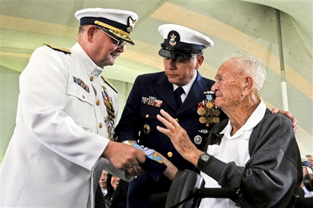 Retired Coast Guard Chief Petty Officer Clyde Allen presents his son, Coast Guard Adm. Thad W. Allen, with his command flag during the U.S. Coast Guard Change of Command Ceremony on Fort Lesley J. McNair in Washington, D.C., May 25, 2010. Coast Guard Adm. Robert J. Papp Jr. relieved Allen as commandant of the U.S. Coast Guard in a ceremony presided over by Homeland Security Secretary Janet Napolitano.