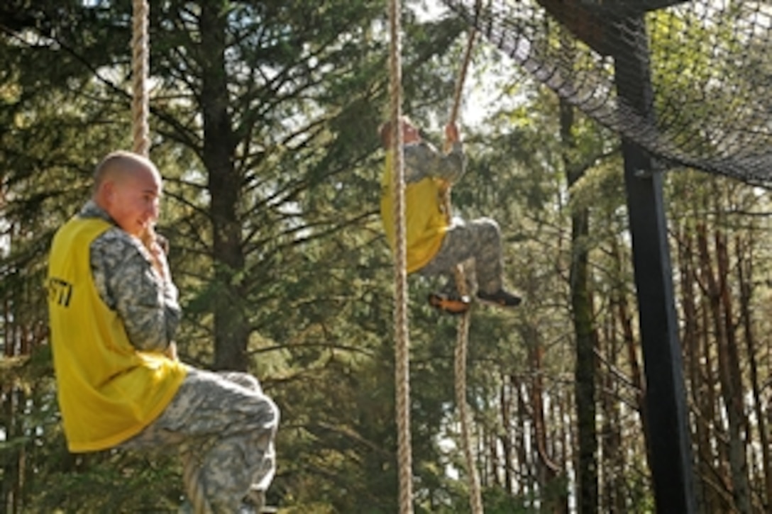U.S. Army Spc. Eric McVay, left, and Sgt. Jared Berkham climb the ropes during the obstacle course event on Camp Rilea, Ore., May 22, 2010. McVay is assigned to the 1st Battalion, 82nd Cavalry, and Berkham is assigned to the 3rd Battalion, 116th Cavalry.