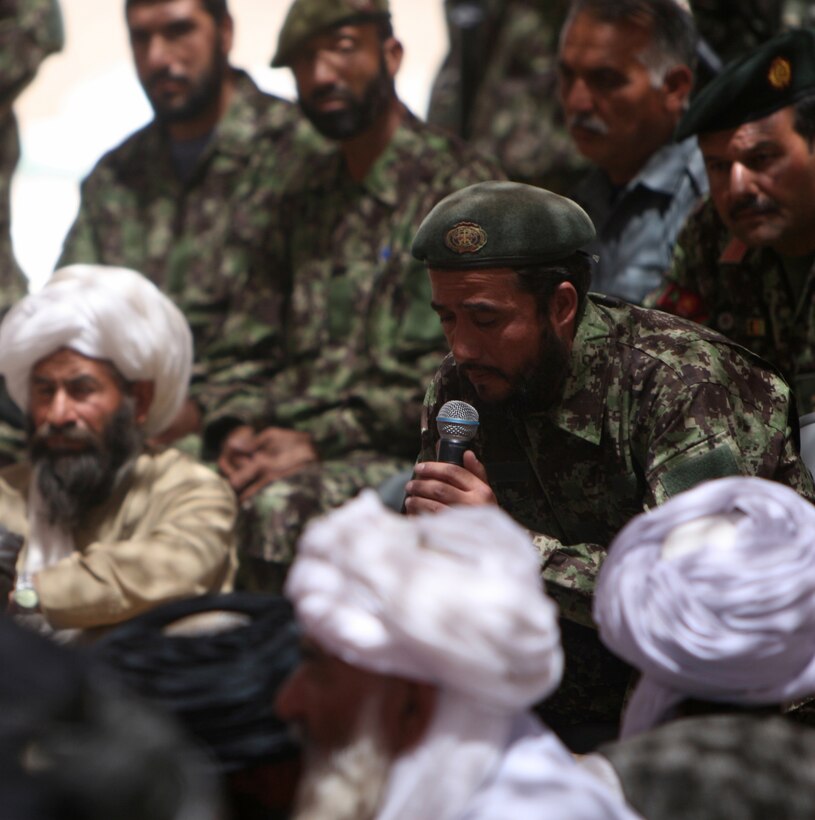 A soldier from the Afghan National Army leads attendees of a shura in prayer prior to the event's start at Forward Operating Base Sher Wali, Marjah, Helmand province, Afghanistan, May 29, 2010. The shura, which was attended by an estimated 410 people, focused on the need for the people of Marjah to unite against the Taliban to improve the area.