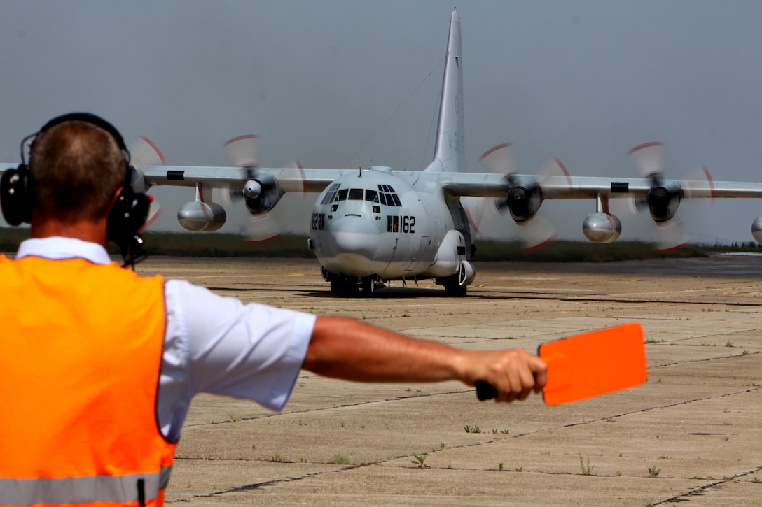 An air traffic controller for the Mihail Kogalniceanu International Airport, Romania, guides a KC-130 aircraft with Marine Aerial Refueler Transport Squadron 234, 4th Marine Air Wing, based out of Fort Worth, Texas, upon arriving at the airport May 28. The unit, along with Marines with VMGR-452, 4th MAW, out of Newburgh, N.Y., is supporting Black Sea Rotational Force 2010 as the air combat element of the Security Cooperation Marine Air-Ground Task Force.