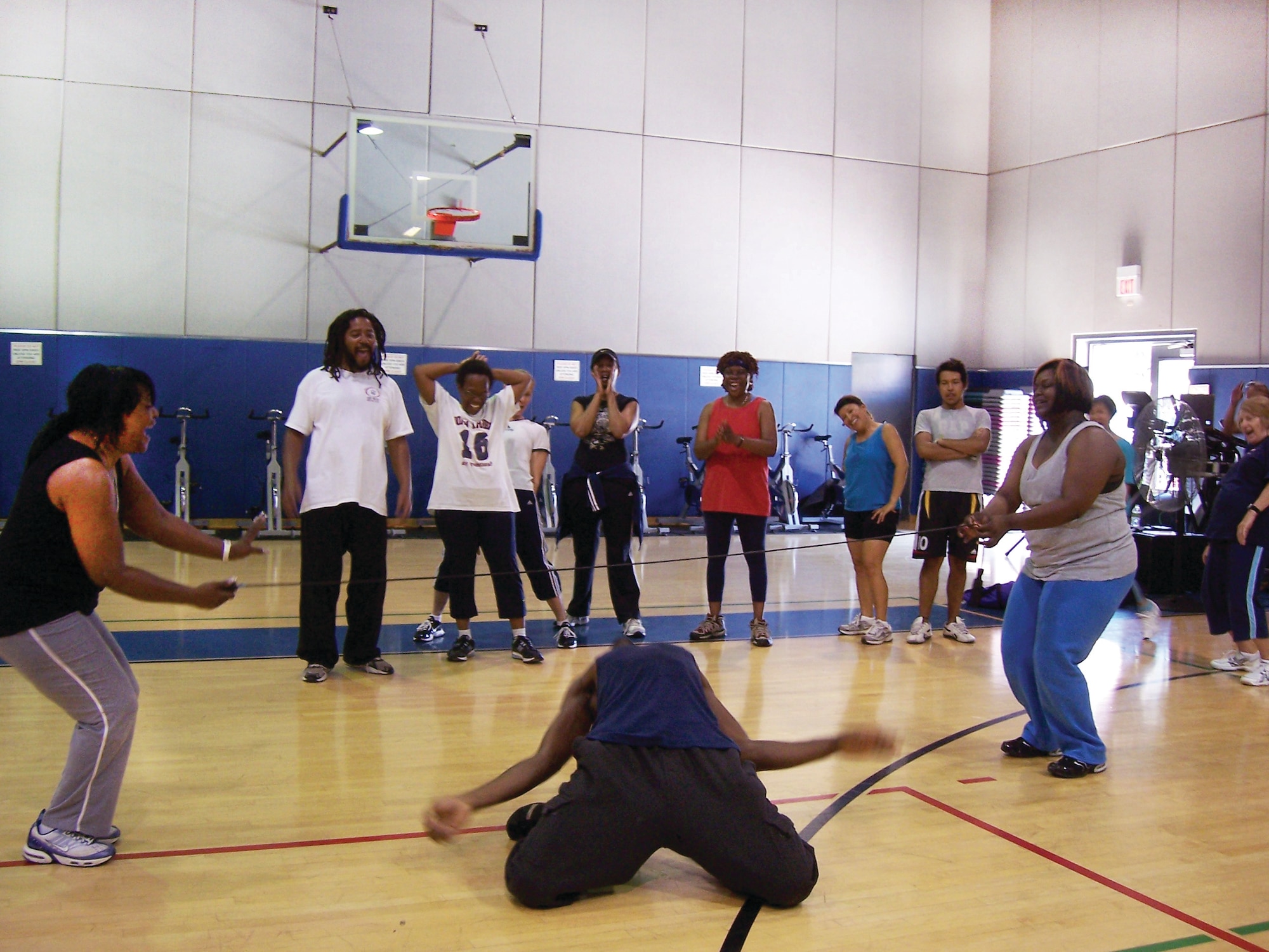 Fitness instructor Chris Keel demonstrate just how low he can go during a round of limbo that was the final event in the "Old School Aerobathon" at the March Air Reserve Base Fitness and Sports Center. The Fitness Center organizes the two-hour Aerobathons quarterly as a way to create fun and challenging workout from a variety of types of exercise. Fifteen Team March members participated in the May Aerobathon, which included spinning, cardio kickboxing, mat work and limbo. Upcoming at the Fitness Center is a morning bike ride, bench press competition and a three-point shoot out competition.  (U.S. Air Force photo)
