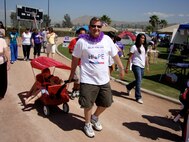 Marvin Tucker, 452nd Mission Support Group, pulls kids around the track in a red wagon. The Moreno Valley Relay for Life May 15-16 raised $15,000 for the American Cancer Society.   (U.S. Air Force photo by Jennifer McDow)