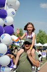 Master Sgt. Phil Hartzell, 452nd Civil Engineering Squadron, gives his daughter a shoulder ride during one of his laps around the track during the Moreno Valley Relay for Life May 15-16.  (U.S. Air Force photo by Jennifer McDow)