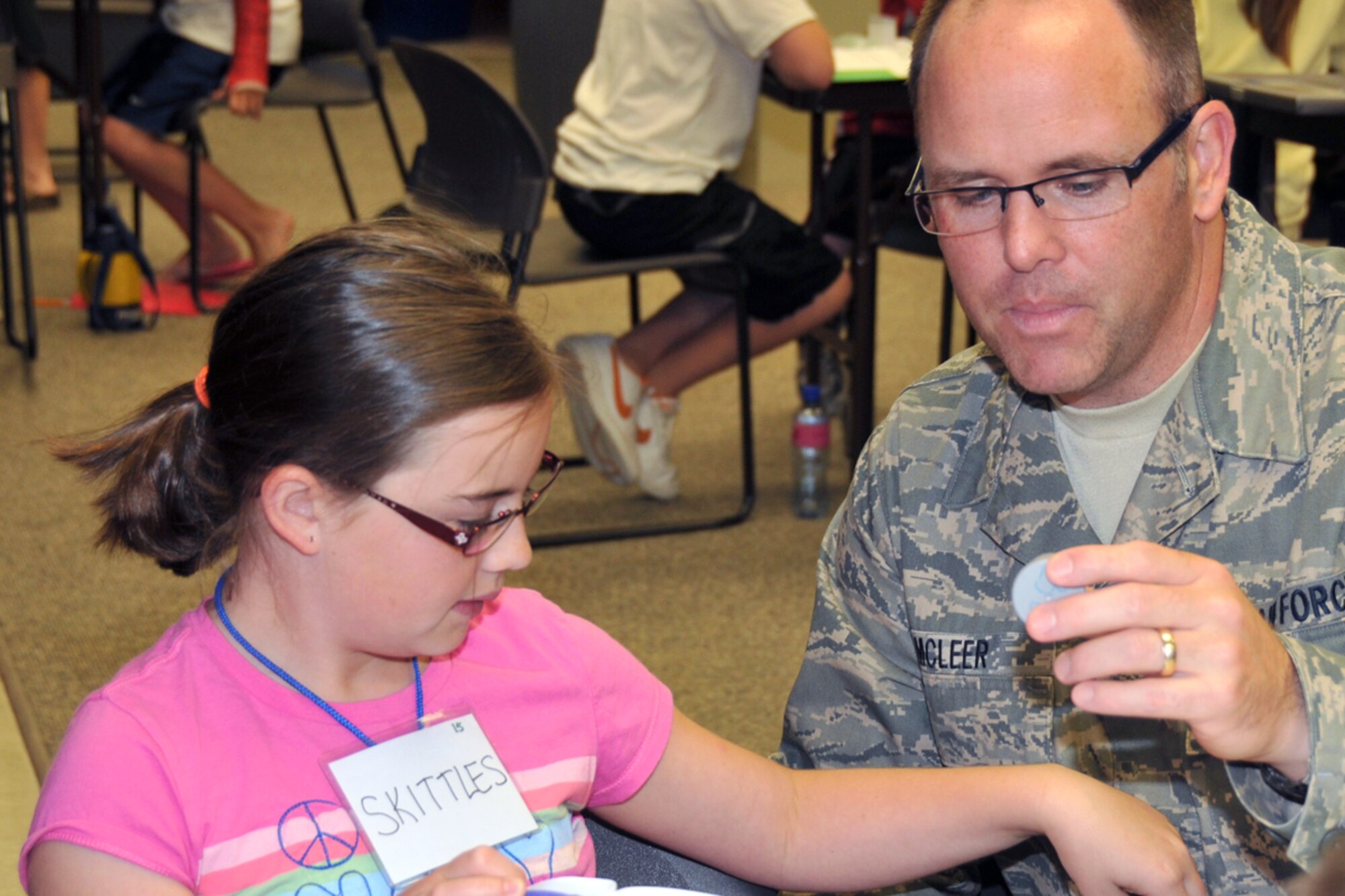 Senior Master Sgt. Donald J. McLeer and his daughter, Madison, call sign Skittles, measure a solution to be used to make slime during STARBASE summer session at Joe Foss Field, SD May 26. (Air Force photo by Master Sgt. Nancy J. Ausland - released)