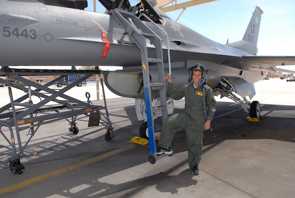 Pilot-for-a-day Alex Ramsperger, 11, stands beside an F-16 Fighting Falcon on the flightline of the 61st Fighter Squadron May 18. (Photo by Airman 1st Class Ronifel Yasay)