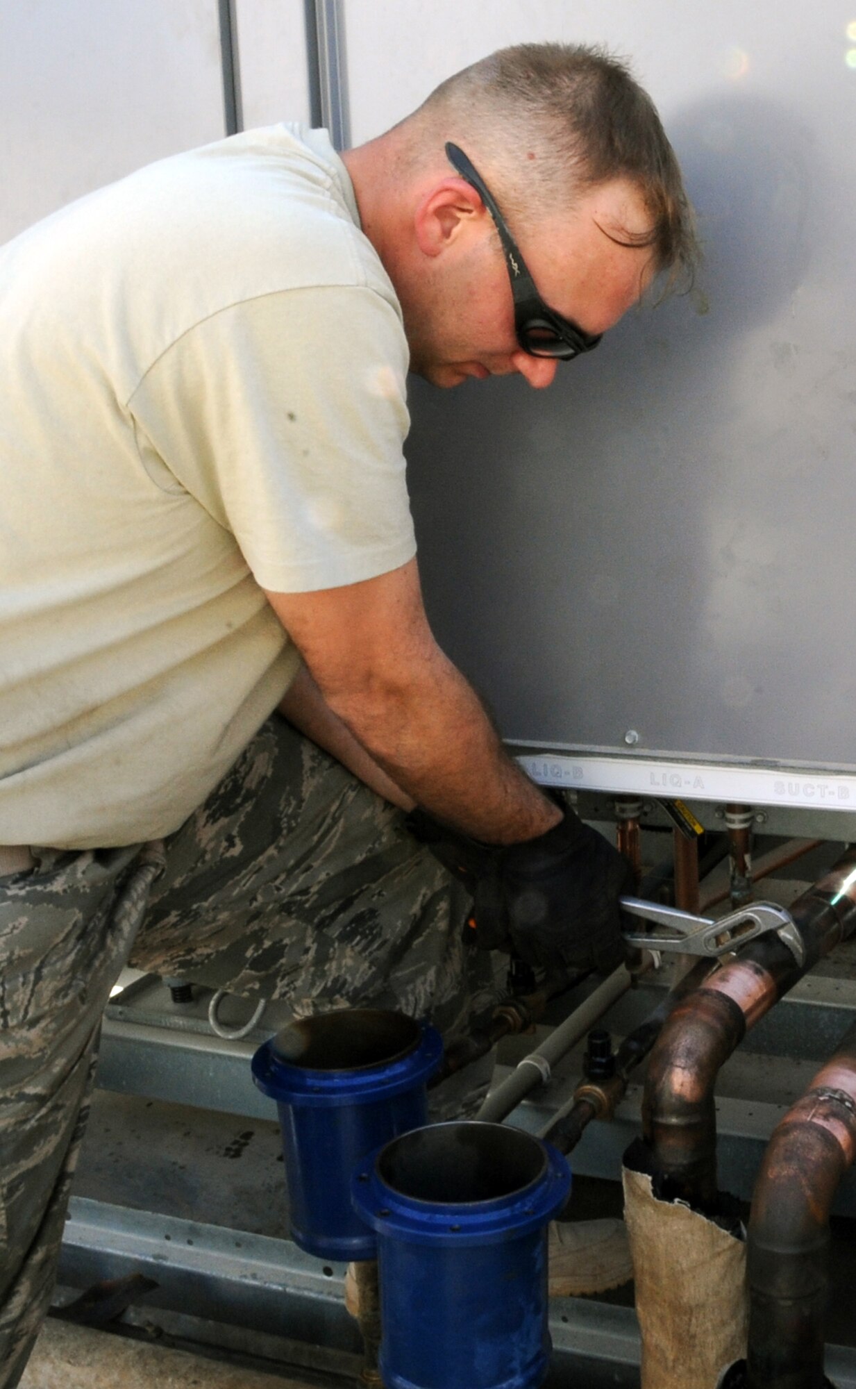 Staff Sgt. Christopher Varnes, a heating, ventilation, air conditioning and refrigeration craftsman with the 380th Expeditionary Civil Engineer Squadron, works on installing an air conditioner for the Oasis dining facility during operations for the 380th Air Expeditionary Wing at a non-disclosed base in Southwest Asia on Feb. 10, 2010. Sergeant Varnes is deployed from the 628th Civil Engineer Squadron at Joint Base Charleston, S.C., and his hometown areas are Charleston and Virginia Beach, Va. (U.S. Air Force Photo/Senior Airman Jenifer H. Calhoun/Released)