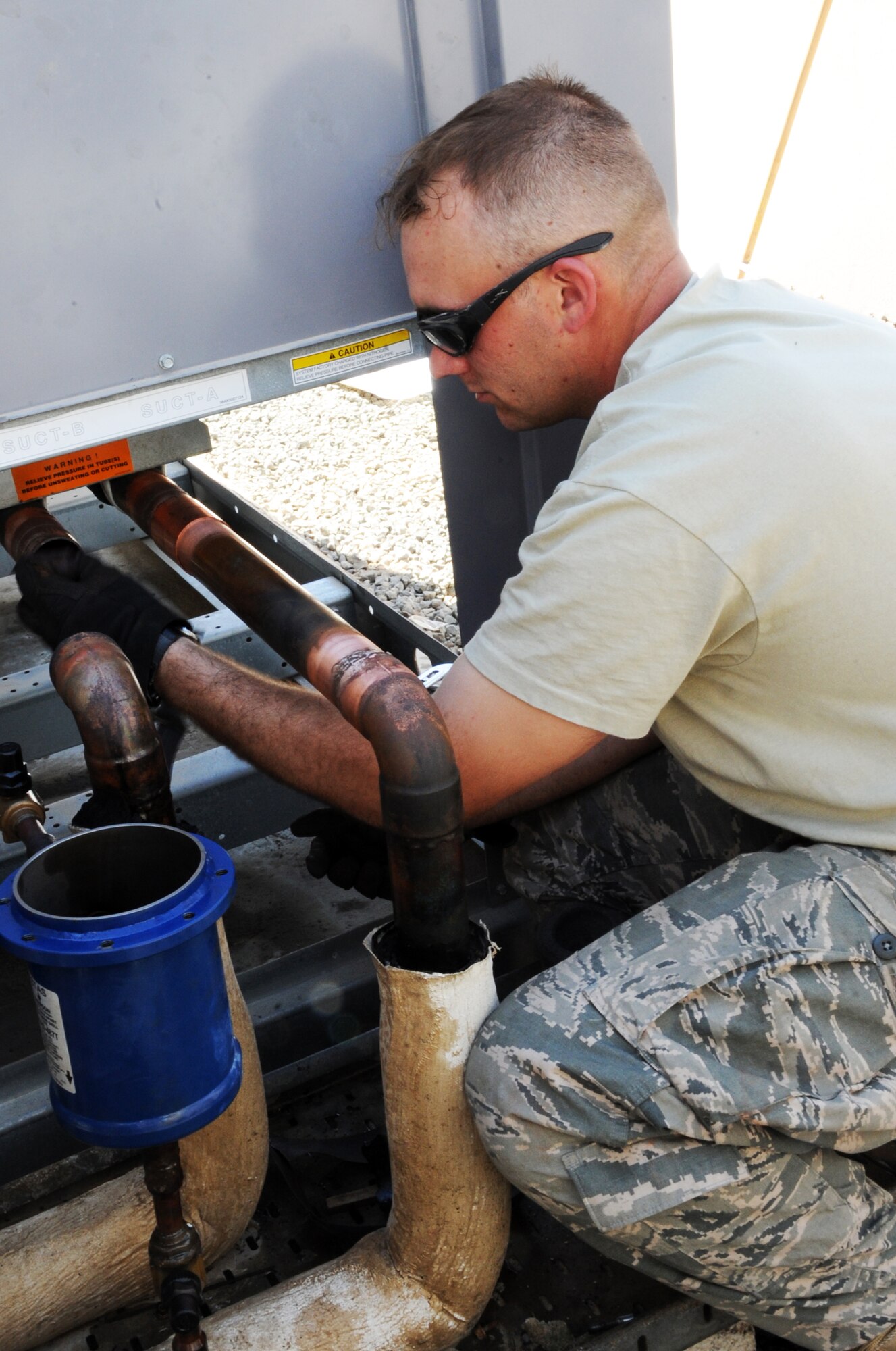 Staff Sgt. Christopher Varnes, a heating, ventilation, air conditioning and refrigeration craftsman with the 380th Expeditionary Civil Engineer Squadron, works on installing an air conditioner for the Oasis dining facility during operations for the 380th Air Expeditionary Wing at a non-disclosed base in Southwest Asia on Feb. 10, 2010. Sergeant Varnes is deployed from the 628th Civil Engineer Squadron at Joint Base Charleston, S.C., and his hometown areas are Charleston and Virginia Beach, Va. (U.S. Air Force Photo/Senior Airman Jenifer H. Calhoun/Released)